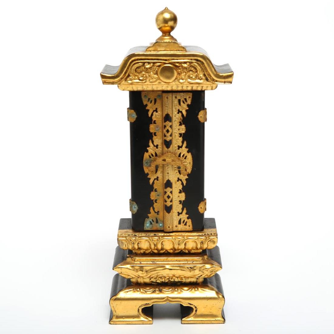 Japanese Buddhist Traveling Shrine: Japanese Buddhist traveling shrine, black lacquer with gilt accent and applied pierced brass decoration, containing with unaffiliated carved wood figure. 10" H X 4.75" W X 2.25" D. Oxidation to hardwa