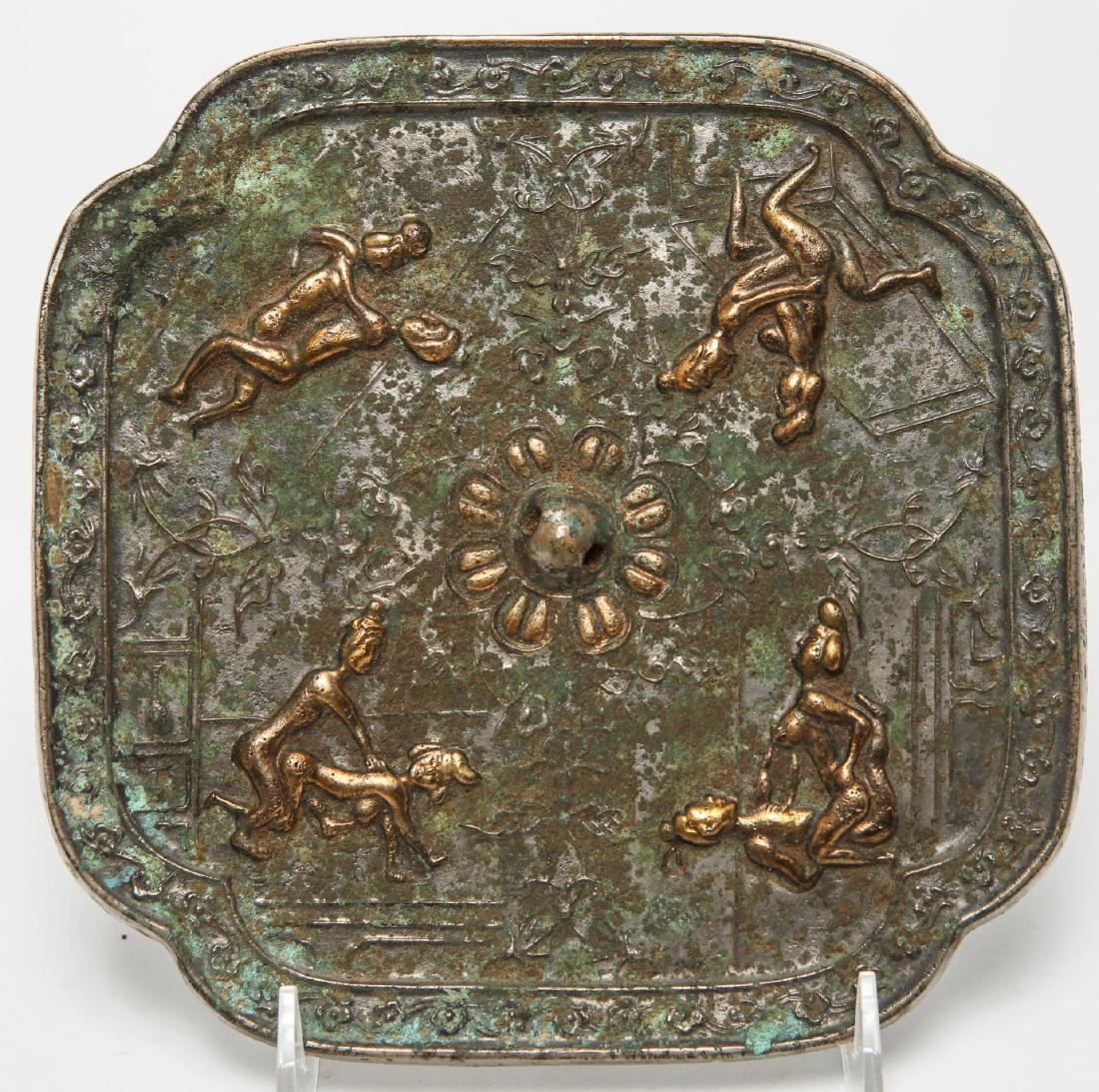 Chinese Tang-Manner Erotic Silvered Bronze Mirror: Chinese Tang Dynasty-manner silvered bronze erotic motif mirror, the flower and scrollwork rim enclosing a raised ring in the center circled by low-relief gilded images of couples engaged in amorous a