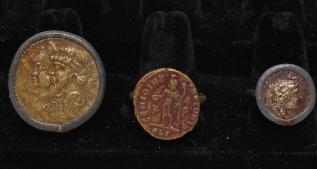 Archaistic Coin Rings, Greek- & Roman-Manner, 3: Archaistic coin rings in the ancient Greek and Roman manner, of varying sizes, one with a king and queen in profile, one with Hercules, one with a standing man. Sizes: 8 1/2 to 10 3/4. Hoops and bezel