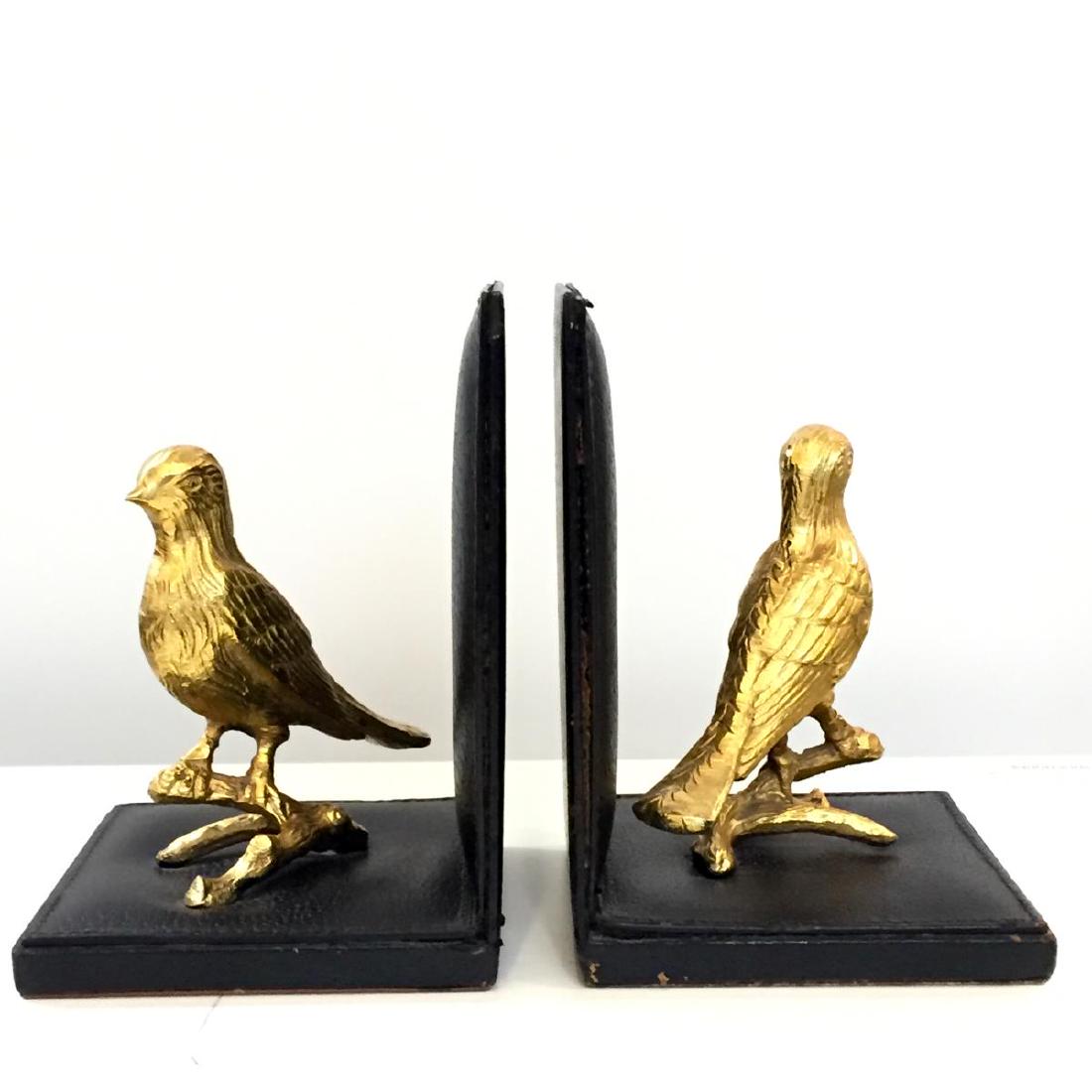 Mark Cross Italy Brass Birds & Leather Bookends: Mark Cross Italy pair of black pigskin leather bookends topped with brass songbirds perched on branches, the natural leather undersides stamped with gilt factory marks. 6.25" H X 5" W X 4.5" D.