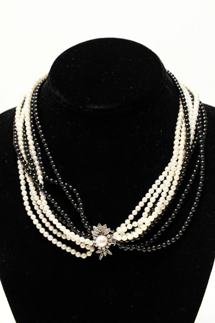 14K Gold Diamond Clasp Black/White Pearls Necklace: 14K white gold diamonds and pearl clasp with eight strands of pearls choker / necklace, four strands of black pearls and four strands of white pearls. 16" L. Gold not weighable.