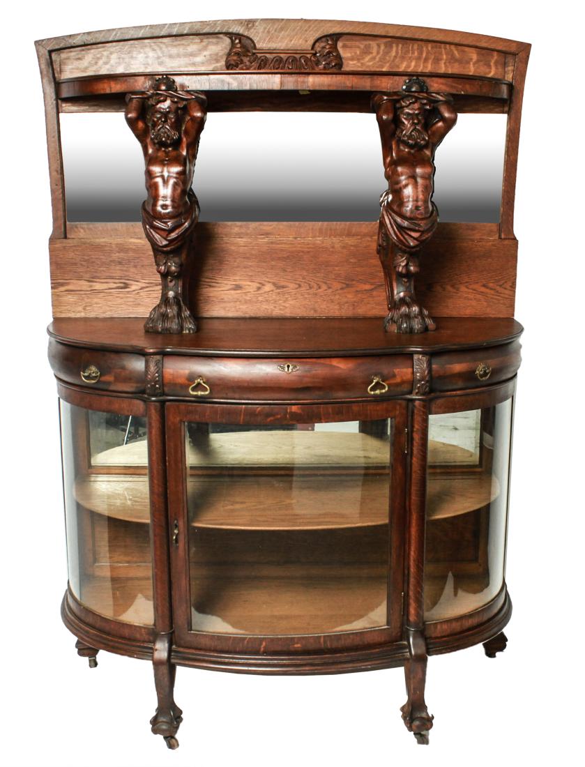 Vict. Tiger Oak w Carved Caryatids Cabinet Buffet: Victorian tiger oak veneer cabinet, beveled mirror back splash shelf with carved wood bearded men caryatids, three drawers above curved glass side panels and door beneath. 72" H x 50" W x 21" D.