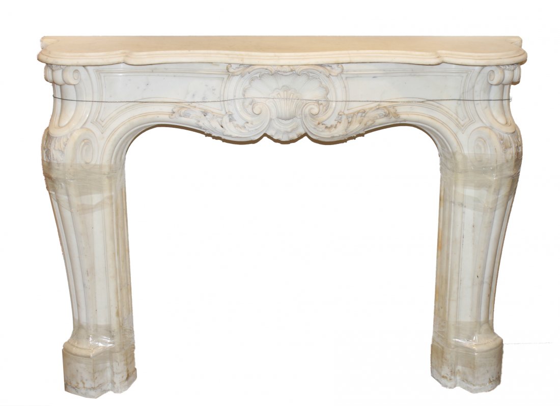 Louis XV Manner Carved Marble Fireplace Mantel: Louis XV manner carved white marble fireplace mantel, serpentine rectangular top with a centered shell and leaves with scroll corners. 38" H x 59" W x 7" D.