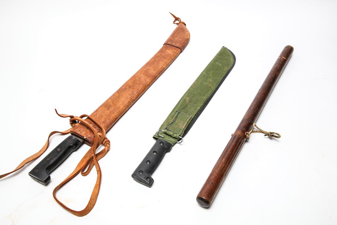 Machetes incl. Collins and Wooden Billy Club 3 Pcs: Group of three weapons comprising one 'Legitmus' Collins & Co. machete with leather sheath, one modern machete with black handle marked "Taiwan" and green canvas sheath, and a wooden club with grooved