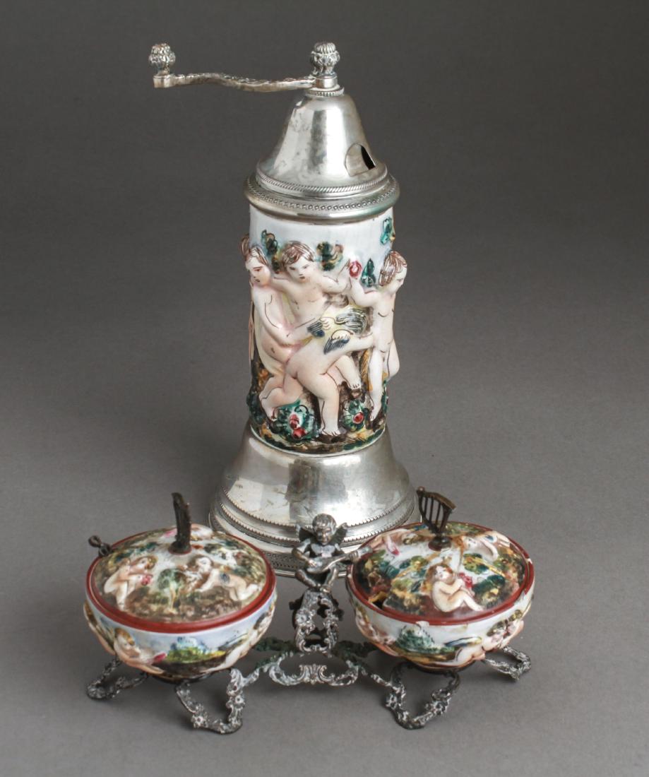 Capodimonte & Silver Condiment & Pepper Mill, 2: Capodimonte manner and Continental silver, two pieces, comprising a porcelain double condiment covered dishes on an open-work silver base with a winged cherub / putti playing a lute, lids with harp mo