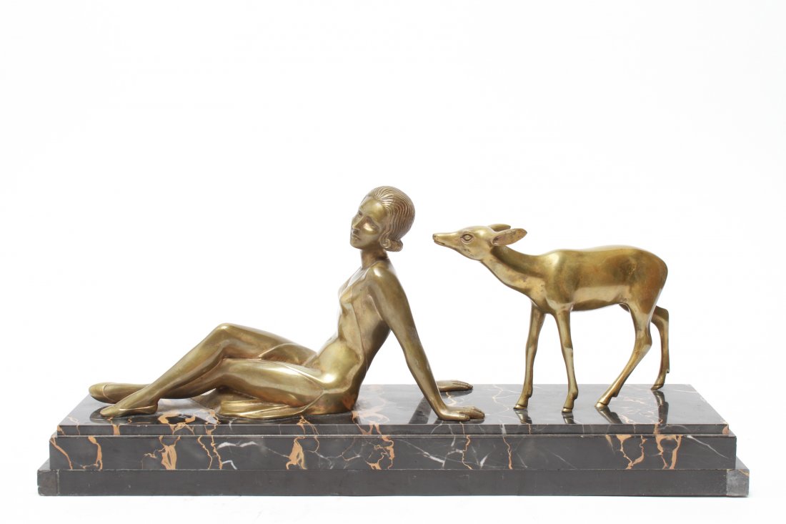 Art Deco Woman & Doe Bronze Sculpture: Art Deco bronze sculpture of a reclining woman and deer on a marble base, marked "Bronze Veritable." 9" H x 5.5" W " x 20.5" L. Base damaged.