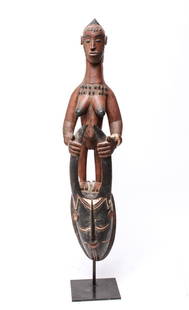 African Guro Horned Mask w Female Figure Sculpture: West African possibly Balle, Guro ram's horned human head surmounted by a female figure tribal sculpture on black metal base. 33.25" H x 6" W x 5.5" base. From the Estate of Actor Miriam Colón.