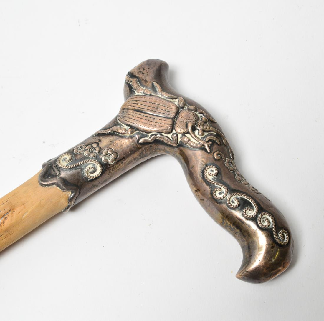 Silver Repousse Beetle & Wood Cane / Walking Stick: Silver repousse beetle, flowers and scrolls, wood cane / walking stick with metal tipped ferrule, marked: "Sterling." 35.5" L. Silver not weighable. Wear to wood surface.
