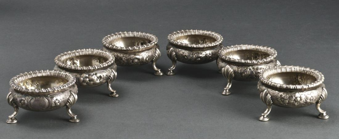 Elkington & Co. Silver Salts w Floral Repousse, 6: Elkington & Co. English sterling silver salts, set of six, floral repousse with tripod base and hoof feet, hallmarked: Elkington & Co / Birmingham / England / 1867." 1.75" H x 2.75" diameter. Approx: 