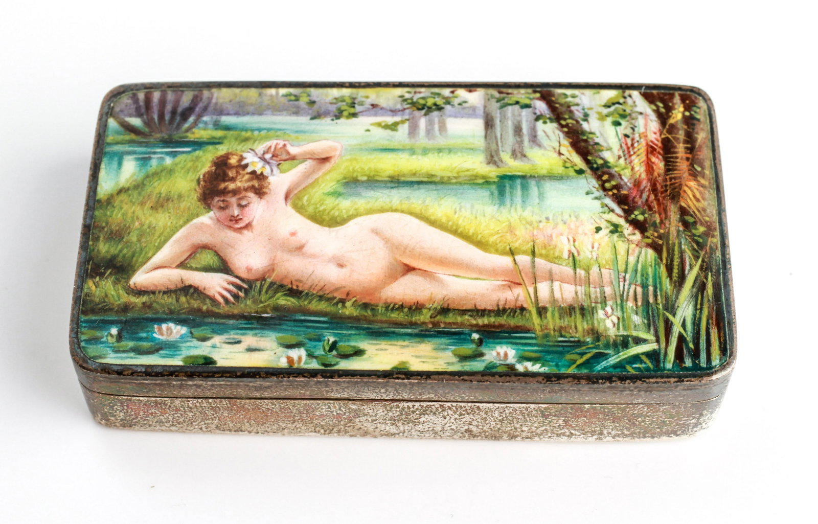Silver & Enamel Erotic Nude Woman Snuff Box: Sterling silver and enamel erotic nude woman snuff box, depicting a reclining nude woman by a stream in a landscape, marked: "935." 1.375" H x 2.625" W. Approx 1.98 ozt inclusive.