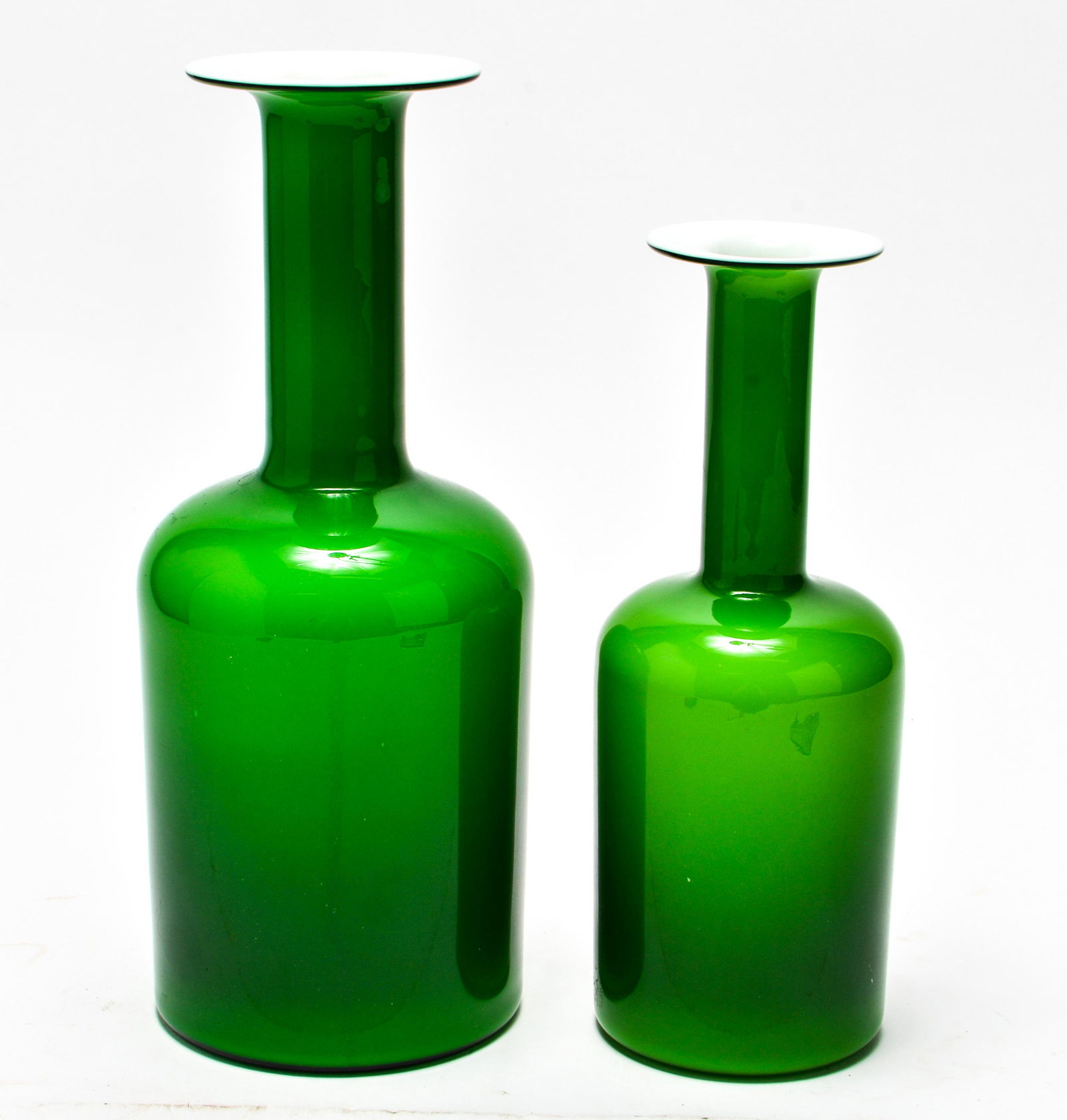 Otto Brauer for Holmegaard "Gulvase" Glass Vases 2: Otto Brauer for Holmegaard "Gulvase" Danish modern green and white cased glass large bottle vases, two. One bearing maker's sticker near bottom. 12" H & 10" H.