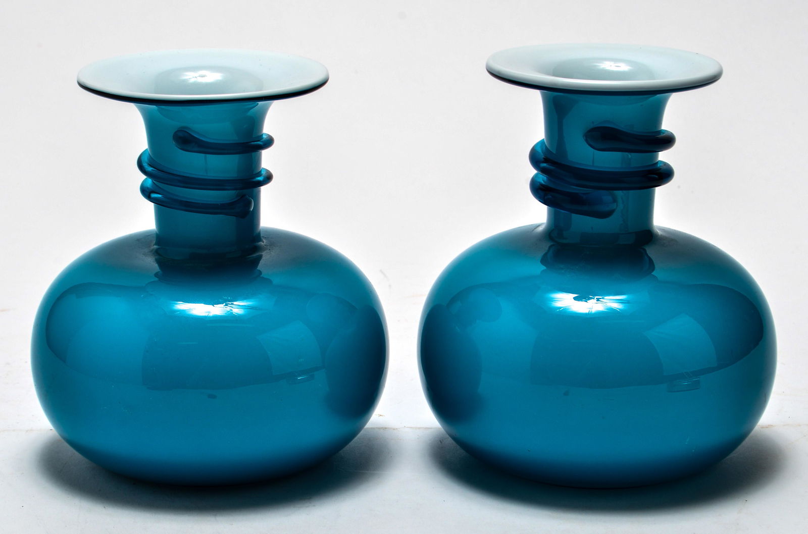 Holmegaard Modern Cased Glass Vases, Pair: Holmegaard Danish modern blue and white cased glass vases, pair with blue threading on necks. 5.25" H.