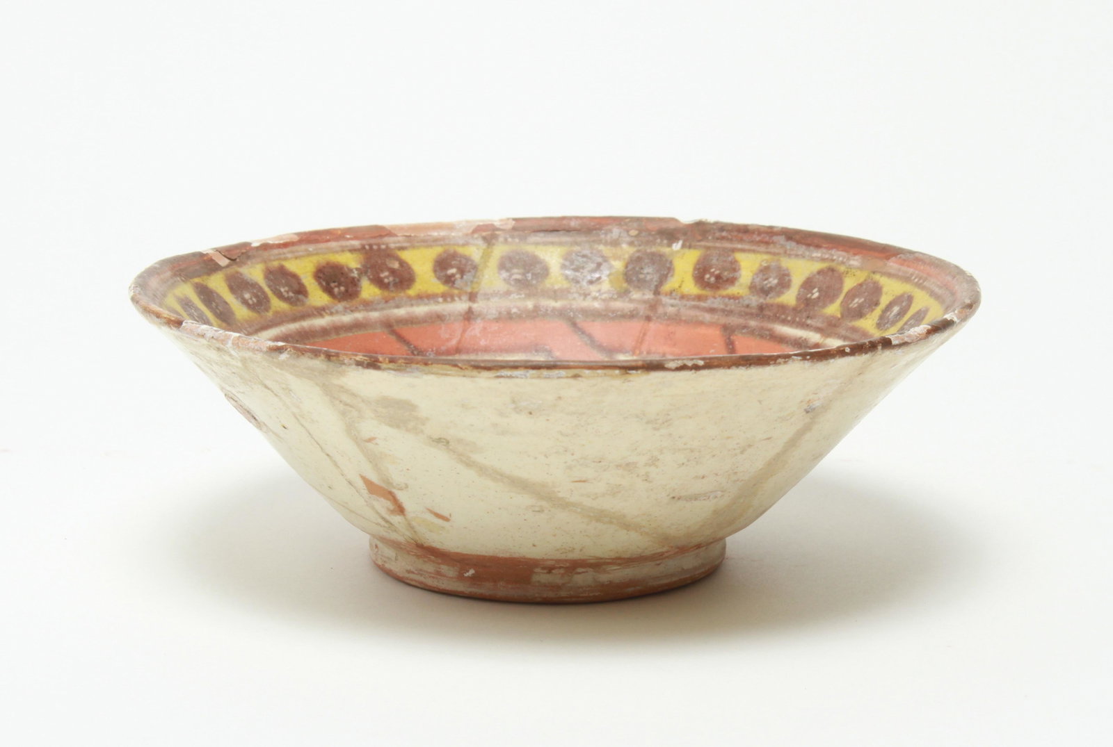 Nishapur Islamic Fritware Pottery Bowl: Nishapur Islamic Persian / Iranian fritware pottery bowl, interior with knot or interlace motif. 2.5" H x 7" diameter. Cracking and repairs, losses and flaking to rim.