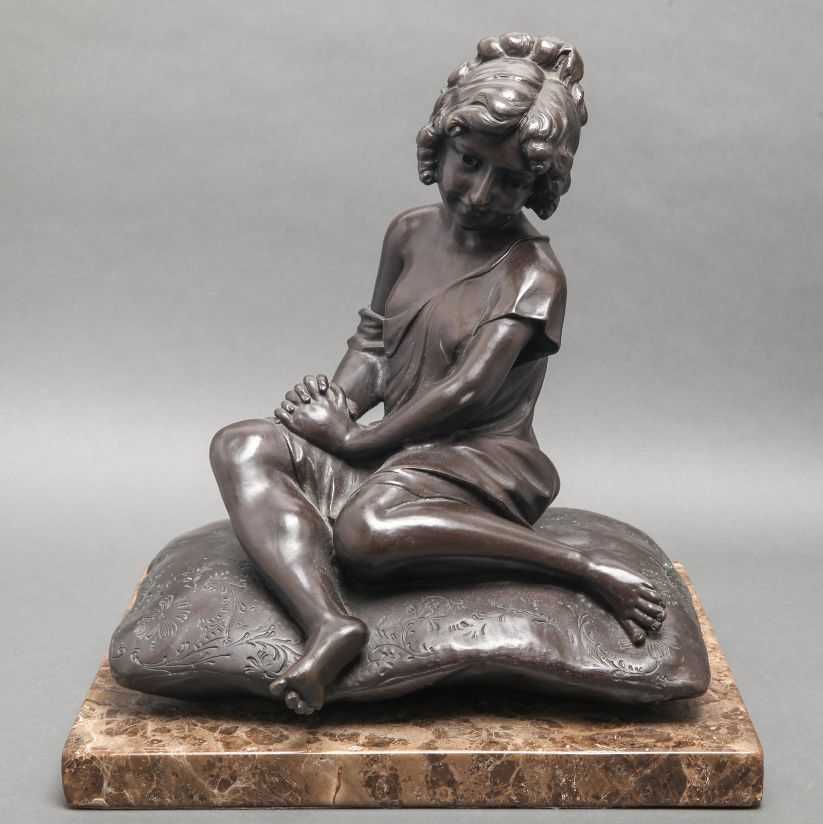 A. Moreau Signed "Girl on Pillow" Bronze Sculpture: Auguste Moreau (French 1834-1917) "Girl on pillow" bronze sculpture on a marble base, depicting a seated girl with her hands clasped, signed "A. Moreau." 15.25" H x 13.25" W x 11" D.