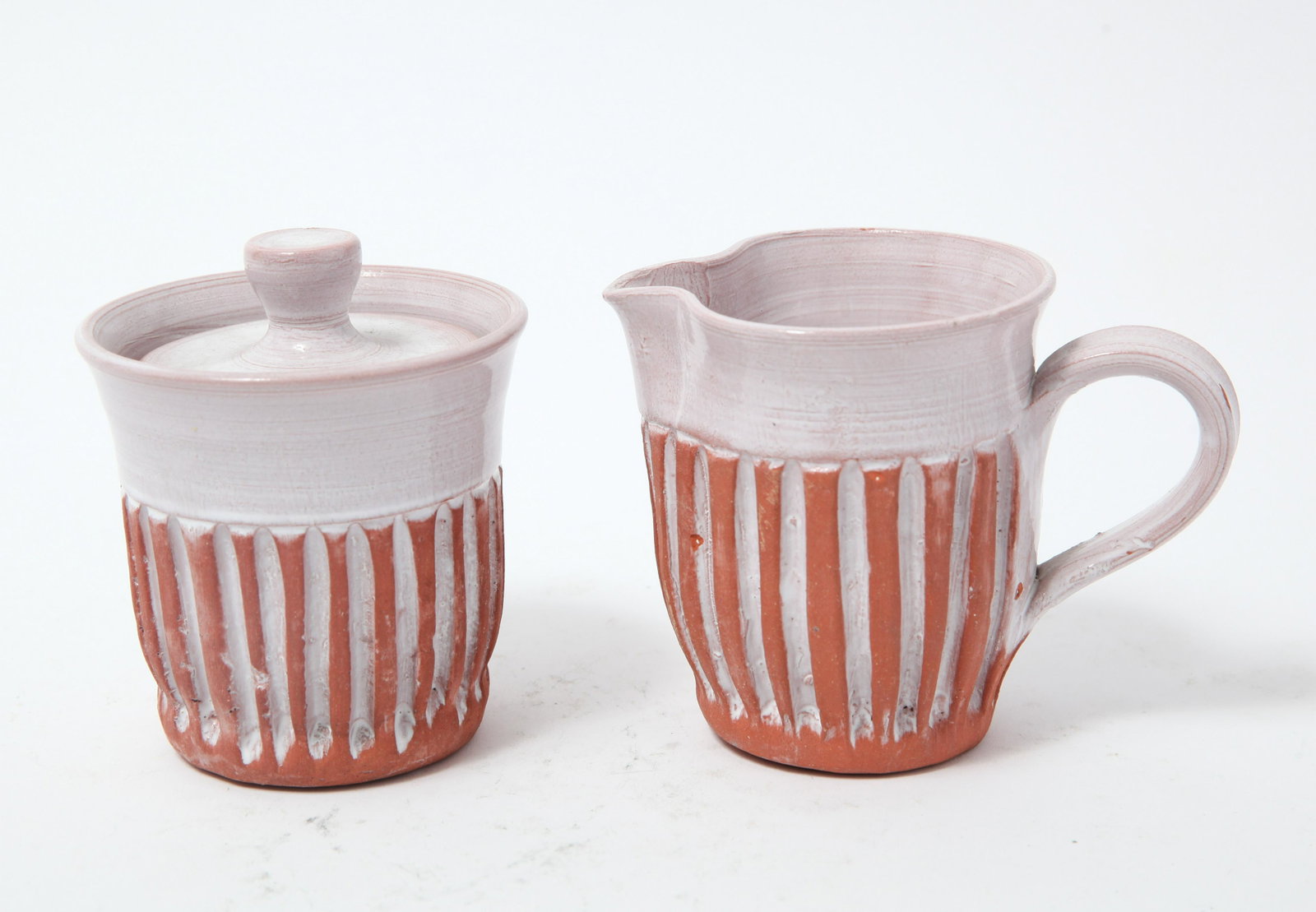 Puerto Rican Pottery: Sugar Bowl and Creamer: Puerto Rican Pottery comprising a sugar bowl and a creamer, signed to underside. 4" H x 3.75" diameter. Chips, losses.