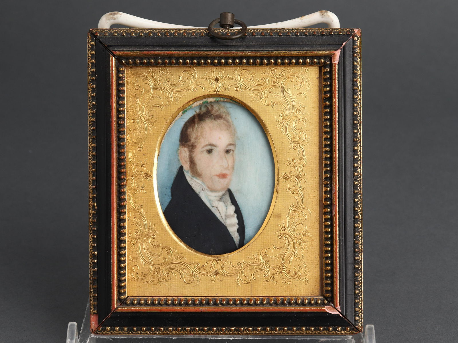 Portrait of a Gentleman Miniature on Bone: Watercolor on bone miniature depicting an oval portrait of a gentleman with blonde hair. Bone: 2.625" H x 2" W; frame: 4" H x 3.5" W. Some foxing.