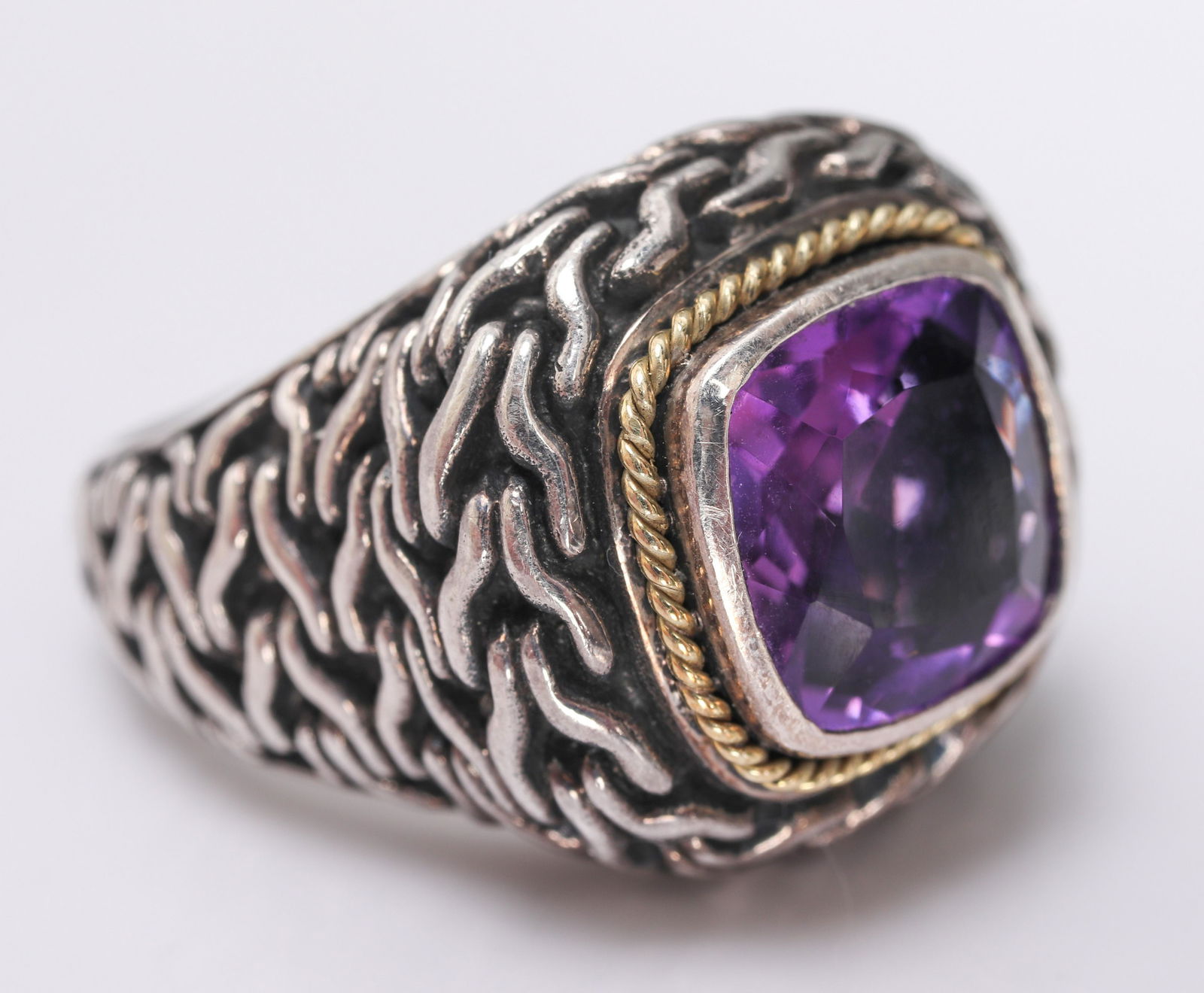Tribal Silver & 18K Yellow Gold Amethyst Ring: Tribal silver and 18K yellow gold amethyst ring, amethyst stone approx: 10mm x 10mm, stamped: "BJC / 925 / 18K." 1.125" L x 0.75" W at widest section. Ring size: 8. Approx: 0.42 ozt inclusive.