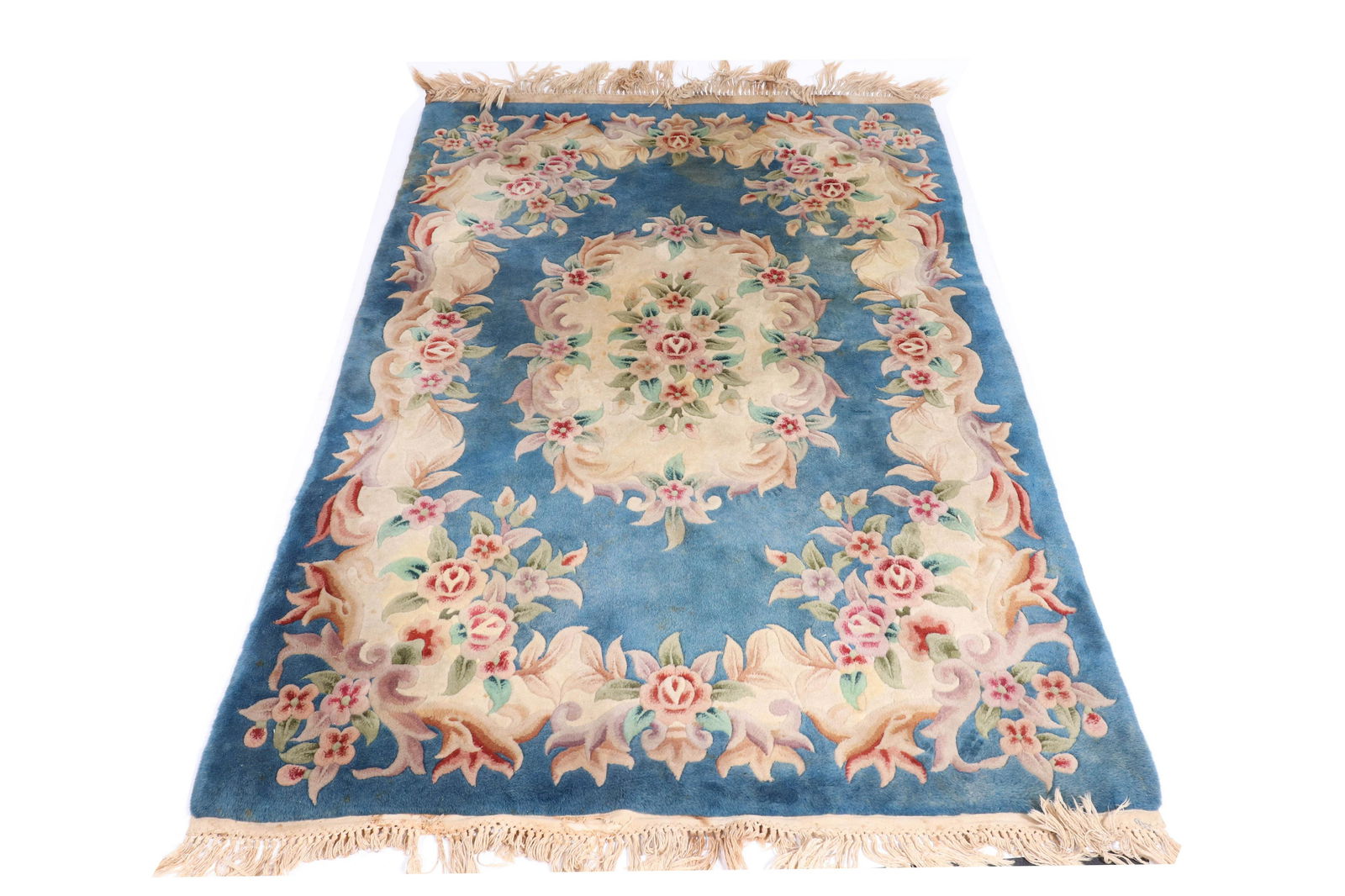 French Floral Pile Rug 6' 6" L x 4' 4": French floral pile rug with center floral center cartouche decoration on deep blue ground with floral floating border. 6' 6" x 4' 4". Pronounced soiling throughout.
