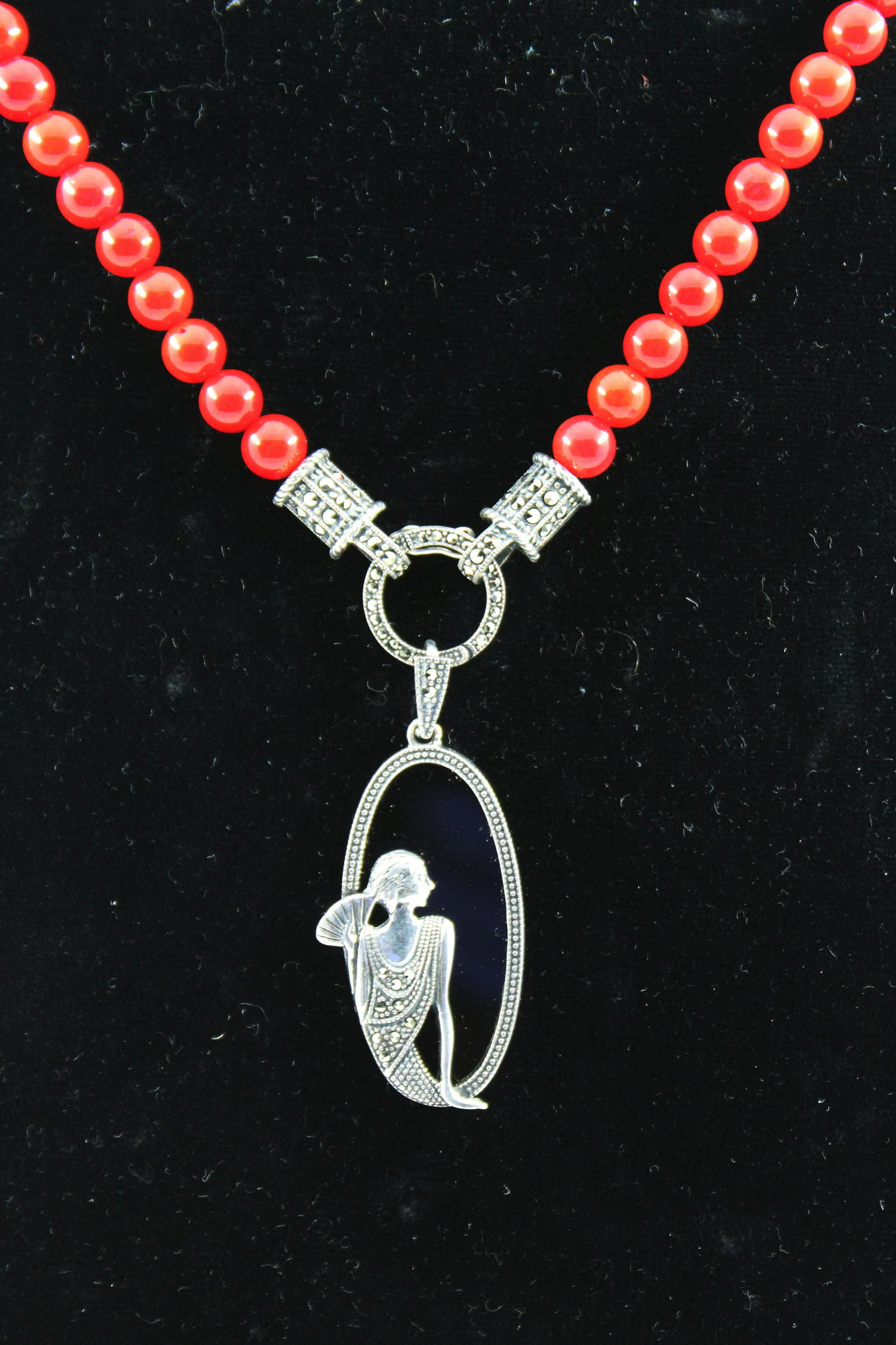 Art Deco Dyed Coral, Onyx & Marcasite Necklace: Art deco dyed coral beaded necklace with onyx pendant featuring woman in profile with marcasite surround in sterling silver setting, marked "AF 925." Strand: 15" L; pendant: 2.5" H. Silver not weighab
