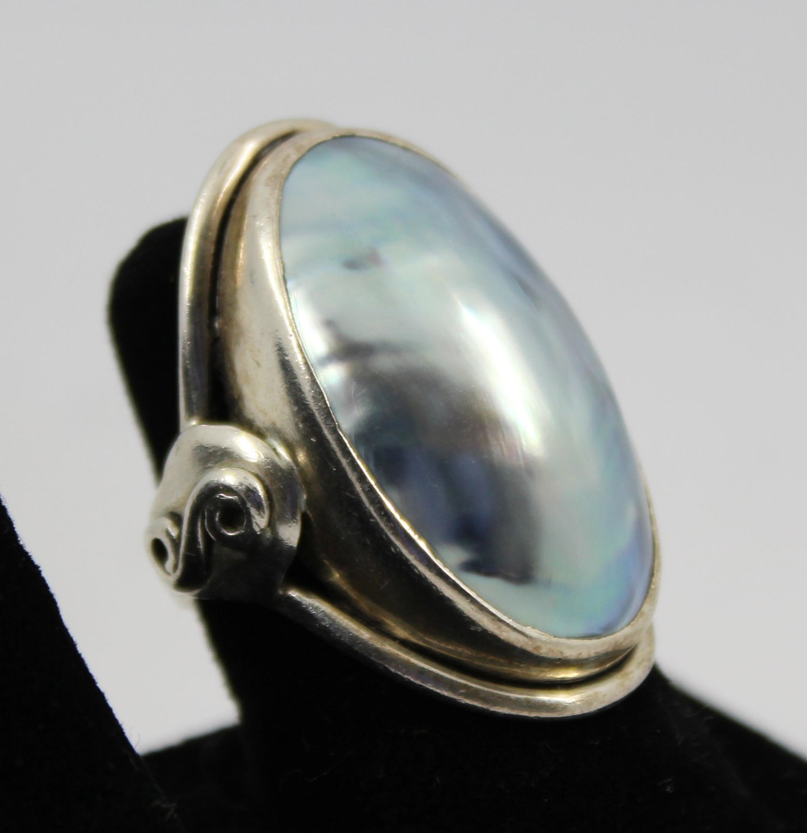 Silver Grey Mother-Of-Pearl Ring: Mother of pearl cabochon set in sterling silver size 6. Approx. .31 ozt (inclusive).
