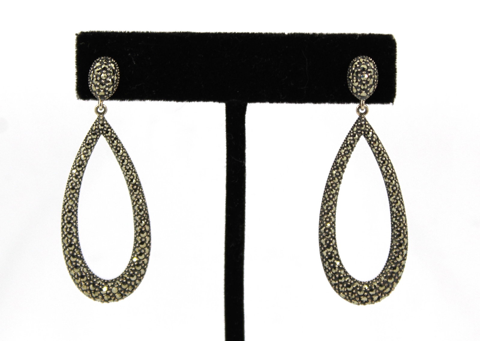 Pair Marc Designer Silver & Marcasite Earrings: Pair of modern Marc designer sterling teardrop earrings encrusted with marcasite on a granulated surface. Marked "Marc" with a crown and "925 / Thailand." Each .75" W. x 2" H. Total .28 ozt inclusive.