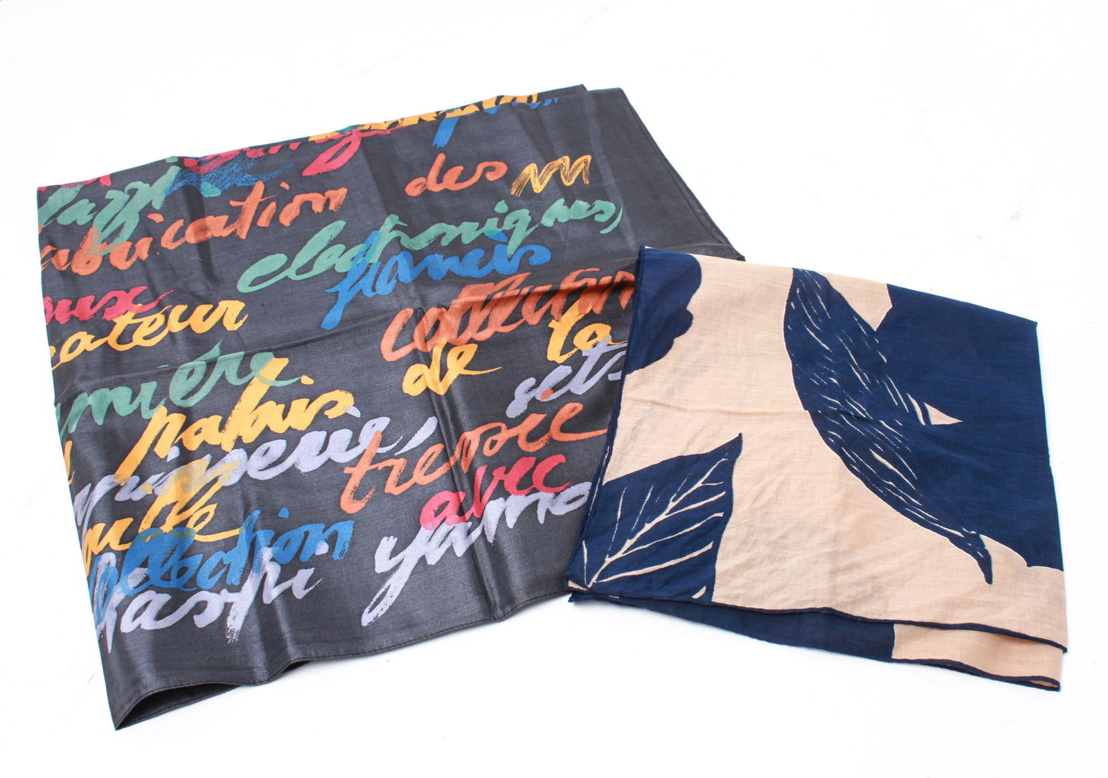 Gaultier & Givenchy Silk Scarves, 2: Two pieces comprising a Jean Paul Gaultier 'Biographie' silk scarf with polychrome text motif, tag with maker's mark, and a smaller Givenchy blue and white scarf, signature panel lower right. Larger:
