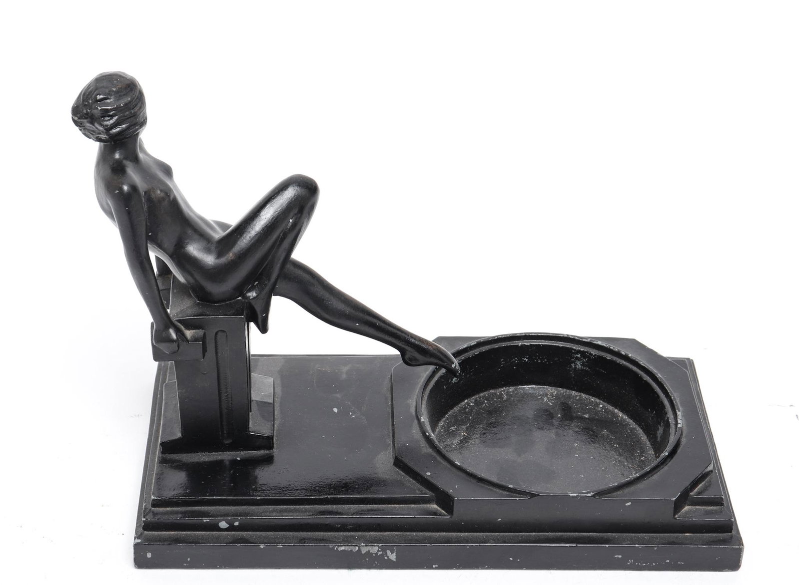 Art Deco Cast Metal Figural Ashtray: Art Deco cast metal figural ashtray, painted black finish, depicting female nude reclining against plinth.7.75" H x 10" W x 5" D. Minor paint loss.