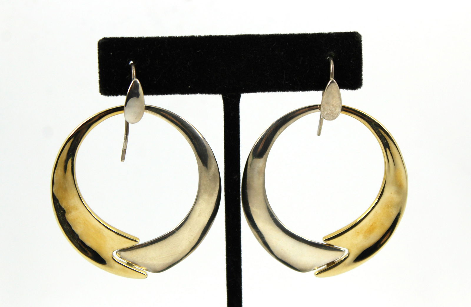 Robert Lee Morris Designer Silver & Brass Earrings: Pair of Robert Lee Morris designer, half sterling silver and half polished brass, oval hoop earrings. Each marked "RLM / Studio" logo and "925 / China." Each 2.25" H. drop x 1.75" W. Silver unweighabl