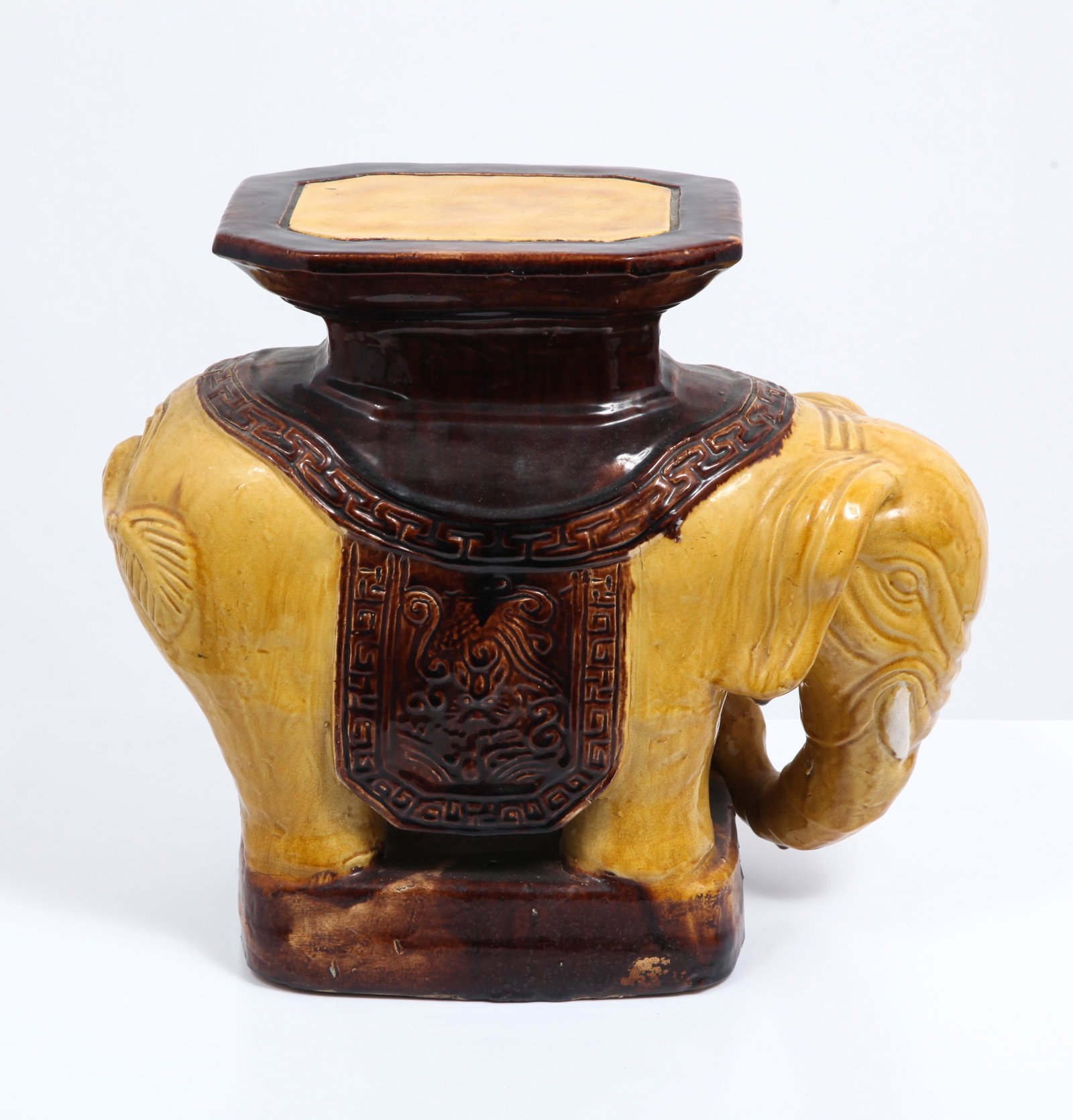 Asian Porcelain Elephant Form Garden Stool: Asian porcelain elephant form garden school with yellow and brown glaze. 15" H x 7" W x 16" D. Crazing, losses to glaze.