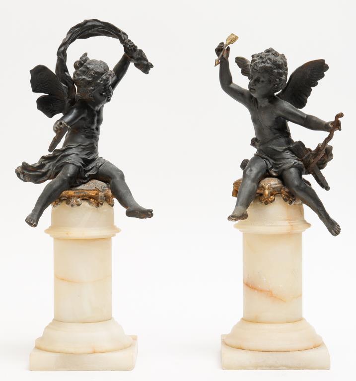 Cherub Sculptures on Alabaster Columns, 19th C.: Pair of 19th century cast metal cherubs seated on gilt metal cushions on alabaster columns. Tallest: 13" H; base: 3.75" square. One cherub holding broken element.