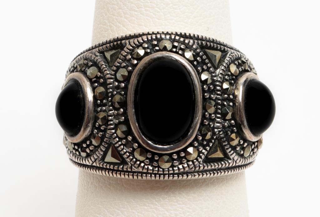 Tribal Silver Onyx & Marcasite Wide Ring: Tribal silver onyx and marcasite wide ring, marked: "A / 925 / THAILAND." 1.0" L x 0.625" W. Center oval cabochon-cut onyx approx: 8.5mm x 6mm flanked by two 5mm x 4mm oval onyx stones. Ring size: 7. 