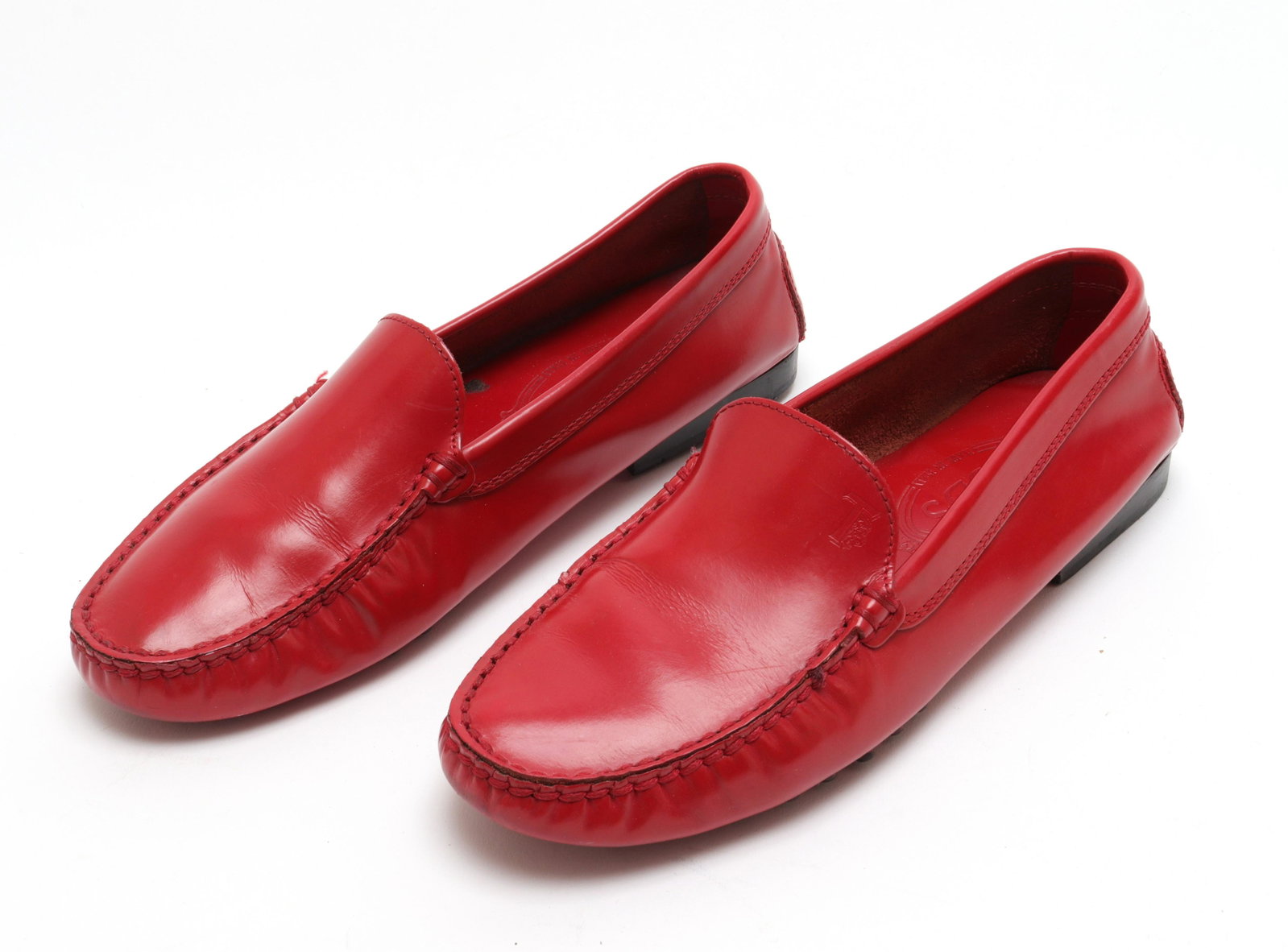 Tod's Red Leather Loafers, Size 7.5: Tod's red leather loafers, with rubber pebble detailing to underside, labeled for designer and size "Tod's Made in Italy / 7 - 1/2" to interior. 10" L. Property of the Estate of designer, model, telev