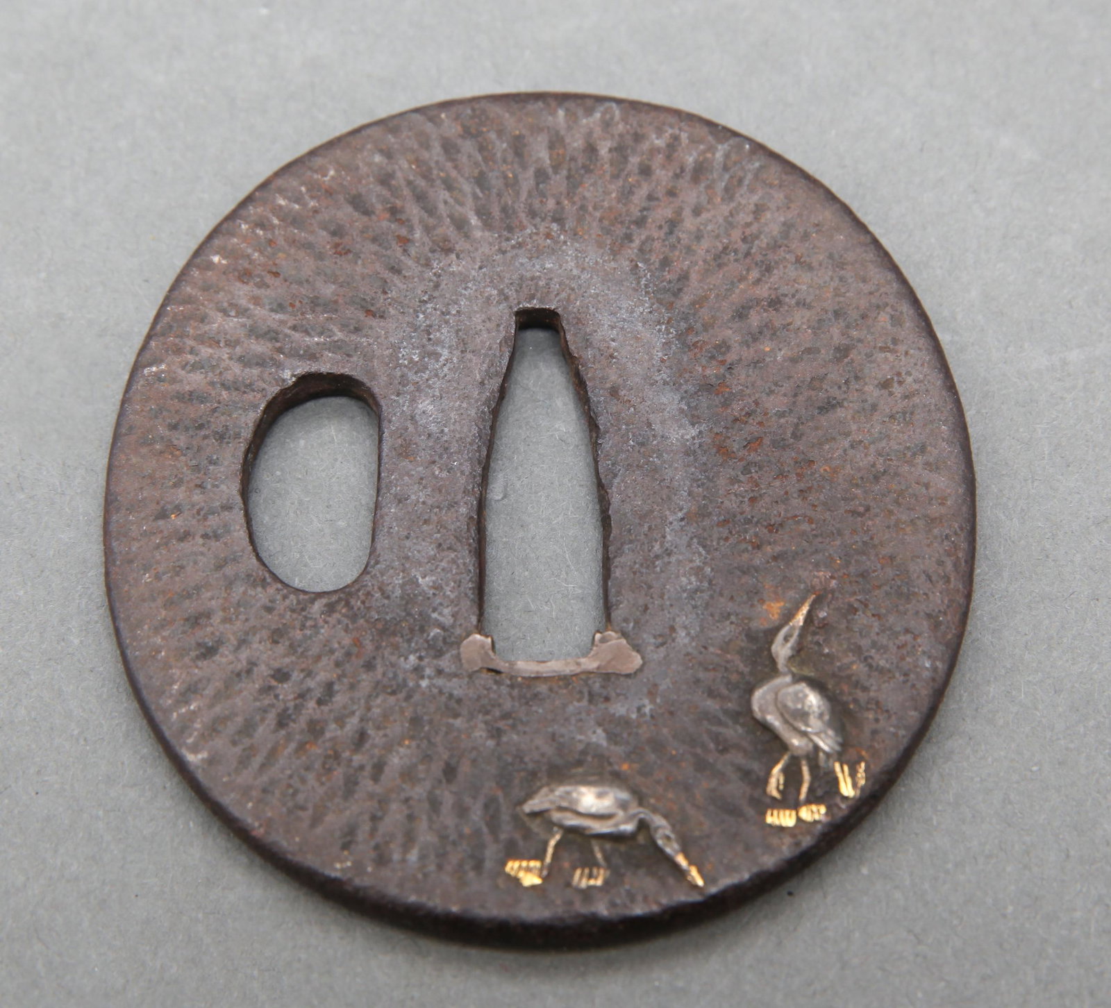 Japanese Tsuba with Crane Decoration: Japanese mixed metal tsuba, chiseled with applied crane decoration and branches to the reverse. 2.625" at widest.