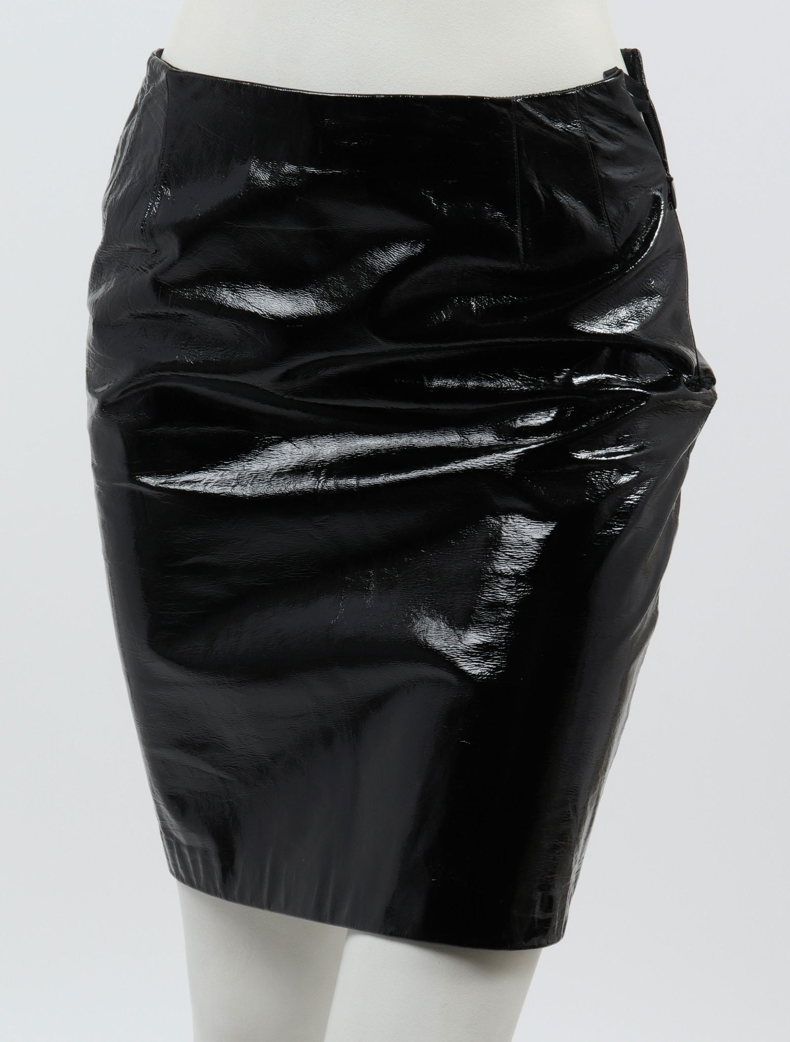 Bill Blass Patent Vinyl Skirt: Bill Blass patent vinyl skirt with side zipper closure, fitted seams at the waist, designer's label "Bill Blass" to interior. Waist: 13" W; hips: 18" W; length to bottom hem: 19.5" L. Some residue to