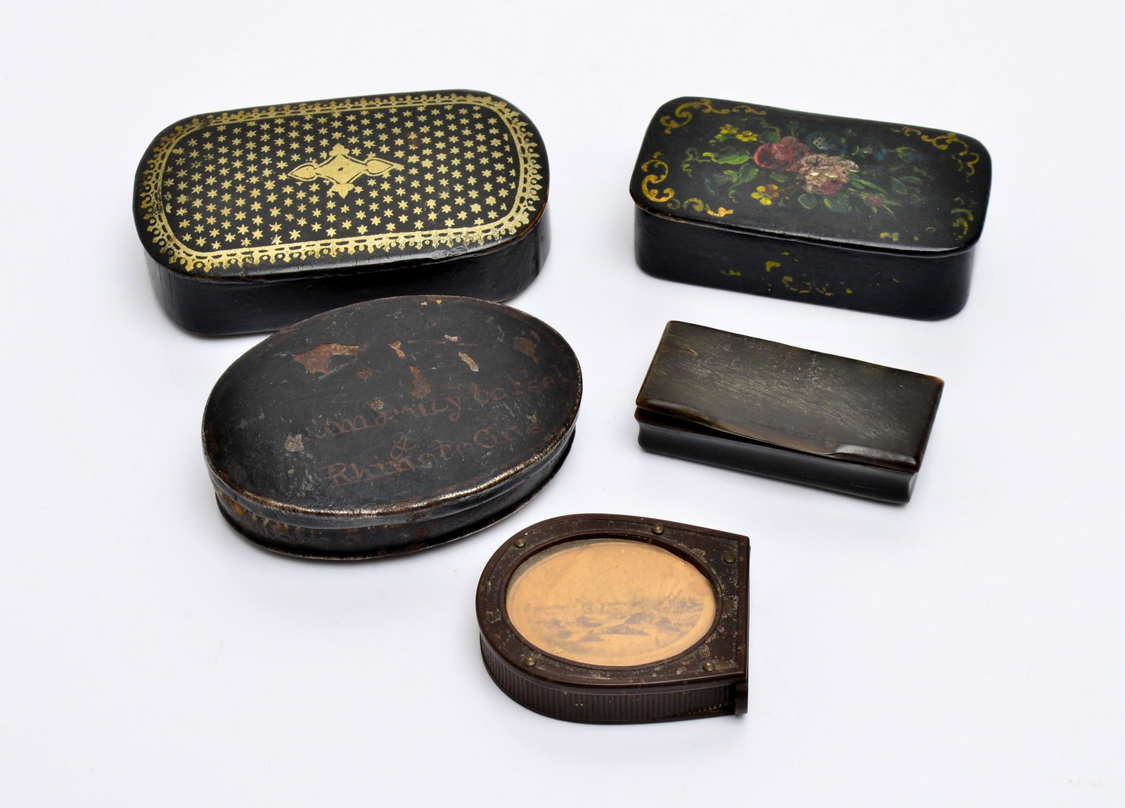 Antique Snuff Boxes & Match Box, Group of 5: Group of five antique boxes, comprising two painted papier mache snuff boxes, one bone snuff box, one tin box with illegible writing, and a vintage celluloid or bakelite match box. 0.75" H x 3.75" W x