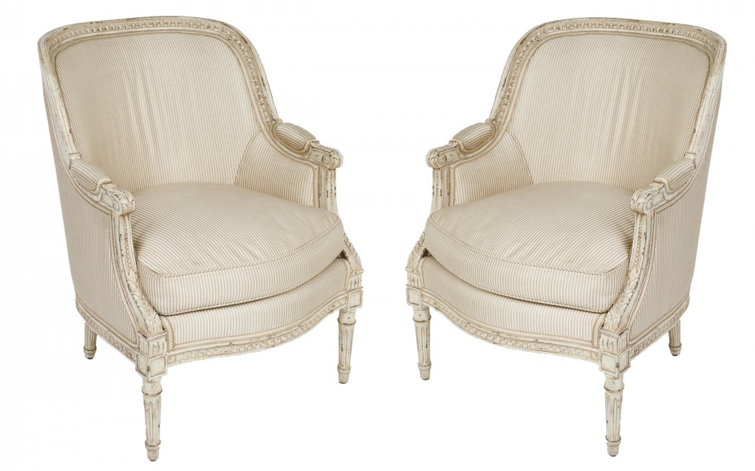 Louis XVI Style Carved & Upholstered Bergeres, Pr: Pair of French Louis XVI style armchairs, carved trim and fluted legs, barrel form backs, with striped upholstery. 35.75" H x 26.5" W x 31" D.