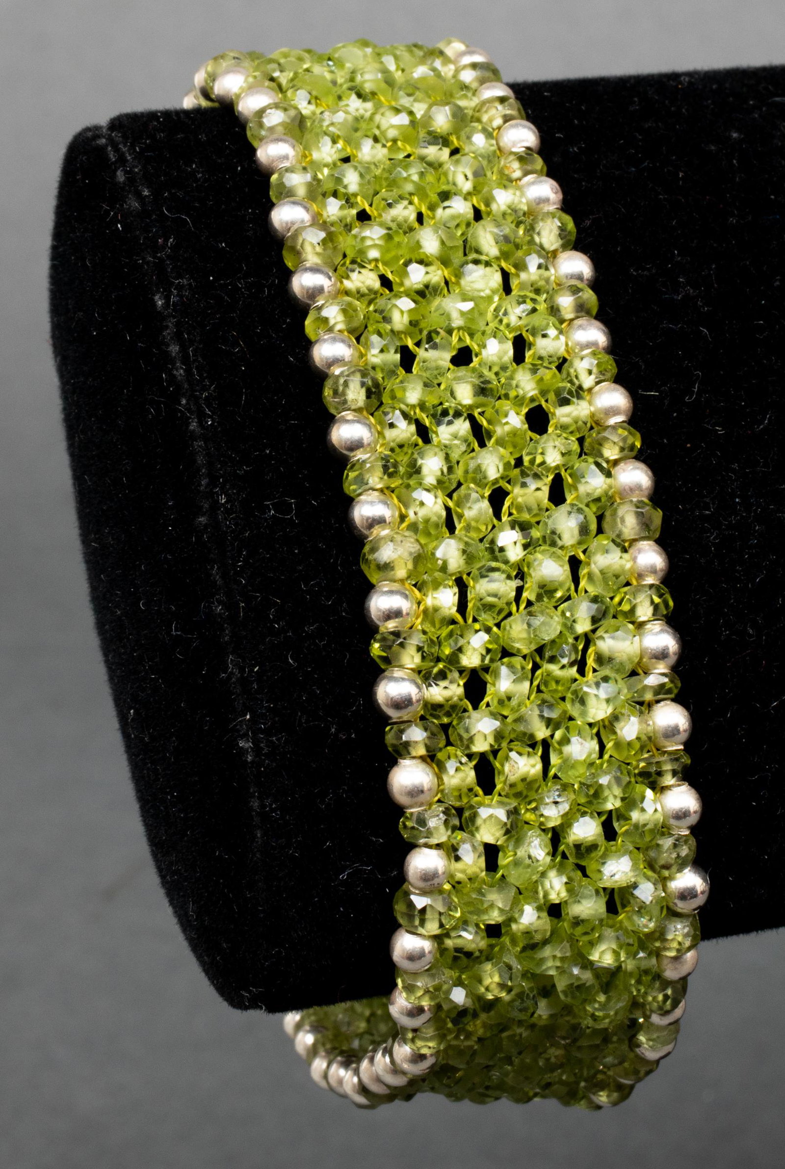 Silver & Peridot Wide Ornate Beaded Bracelet: Silver and peridot wide ornate beaded bracelet, marked: "INDIA / 925 / SI." Bracelet measures 7.5" L x 1.0" W. Approx: 0.95 ozt. inclusive.