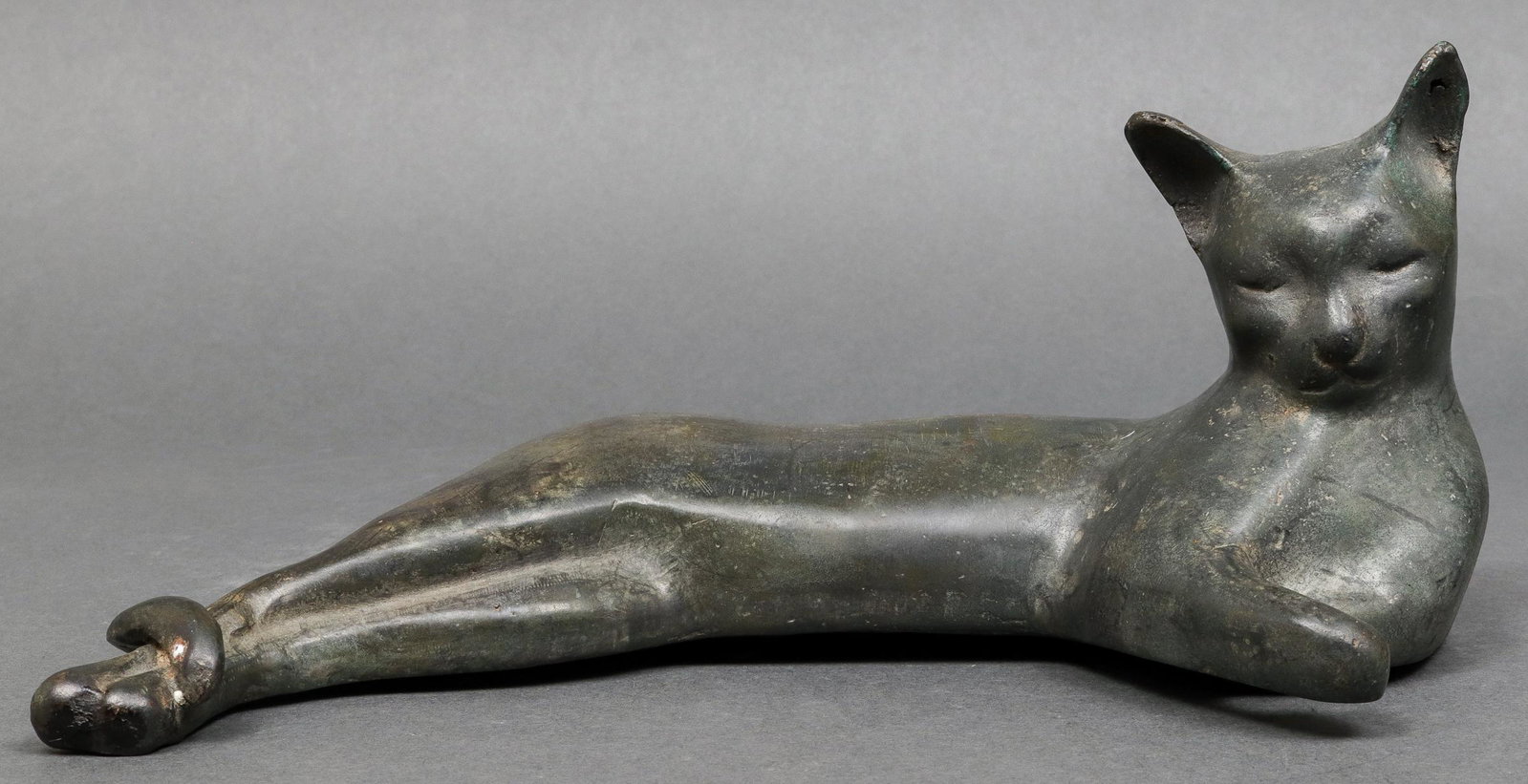 "Sleeping Cat" Modern Bronze Sculpture: Modern bronze sculpture depicting a reclining cat. 4.25" H x 9.5" L x 4.75" D.
