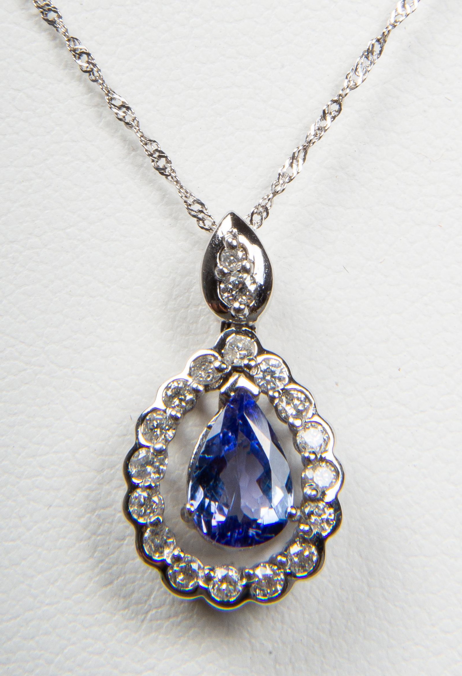 14K White Gold Tanzanite & Diamond Pend. Necklace: 14K white gold tanzanite & diamond pendant necklace, composed of one 9mm x 6mm pear shaped tanzanite surrounded by sixteen round brilliant-cut diamonds and two diamonds on bail, diamonds approx: 0.36 