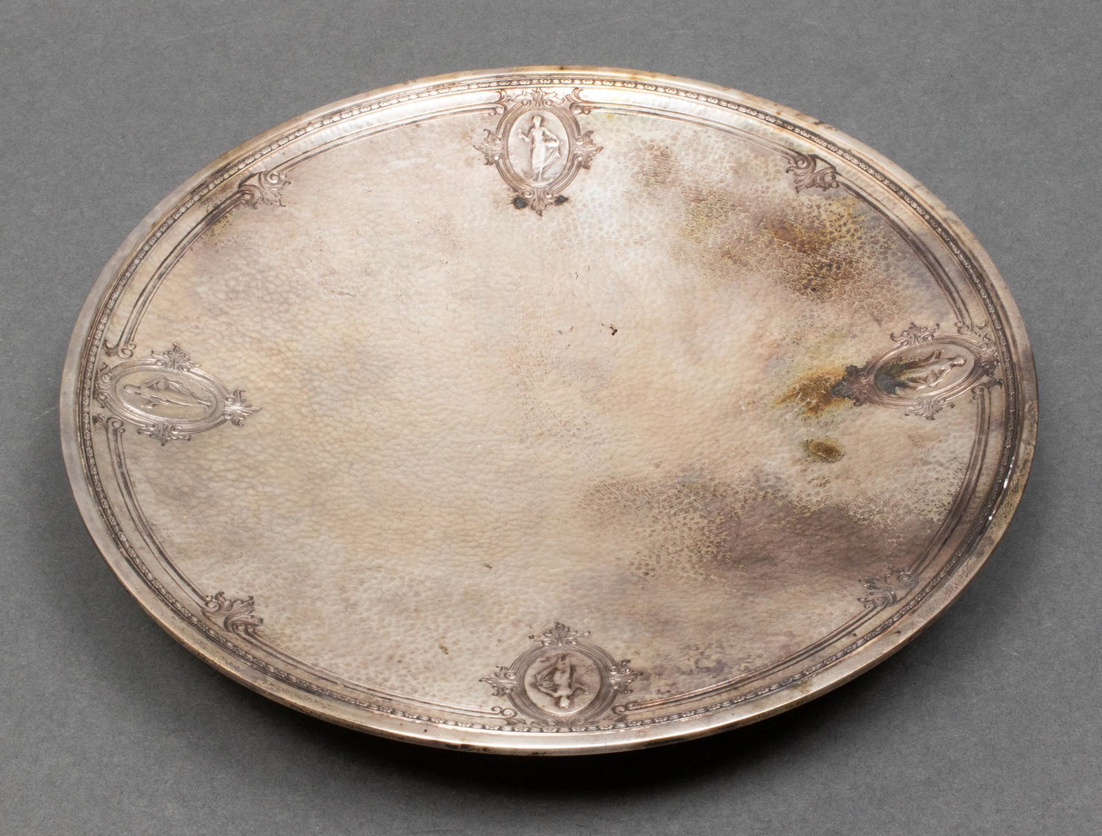 Watson Co. Neoclassical Style Hammered Silver Dish: Watson Company (North Attleboro, Mass) Neoclassical style sterling silver footed dish, with repousse figural medallions and allover hammered finish, maker's mark underside and numbered: "9198." 1.5" H