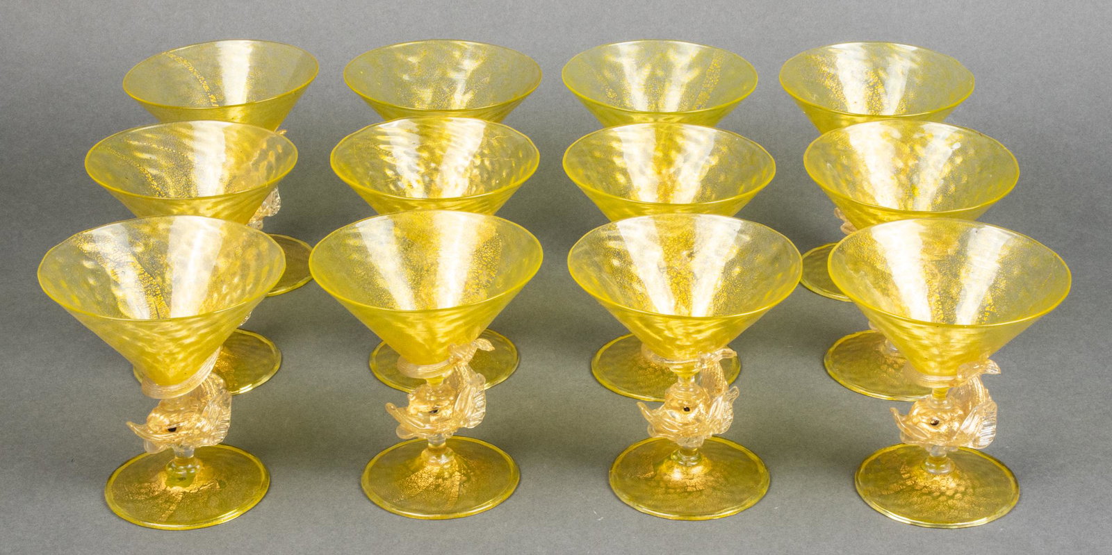 Venetian Murano Glass Dolphin-Stem Glasses, 12: Venetian Murano aventurine glass dolphin-stem cocktail glasses in the manner of Salviati, set of twelve. 4.75" H; base: 3.125" diameter. One with minor loss to tail.