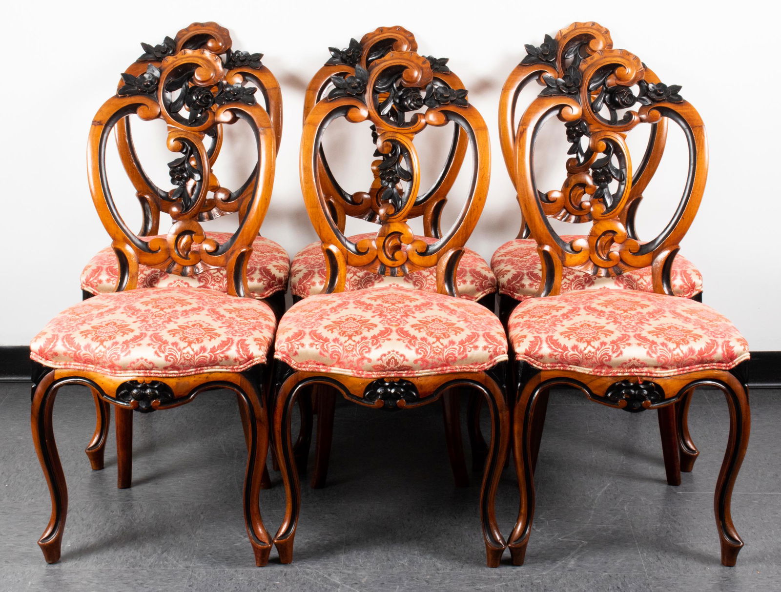 Rococo Style Carved Dining Chairs, Set of 6: Rococo style carved wood dining chairs, set of six, all side chairs, with carved ebonized flower details, damask upholstered seats. 38" H x 18" W x 20" D. One with repaired leg.
