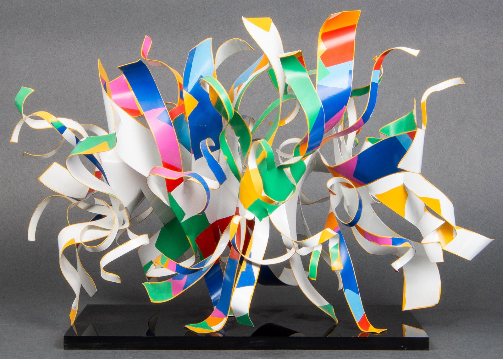 Dorothy Gillespie Abstract Modern Ribbon Sculpture: Dorothy Gillespie (American, 1920-2012) abstract modern ribbon sculpture, polychrome enameled aluminum ribbons on a smoky acrylic base, signed to one ribbon "Dorothy Gillespie." 12" H x 12.5" W x 6" D