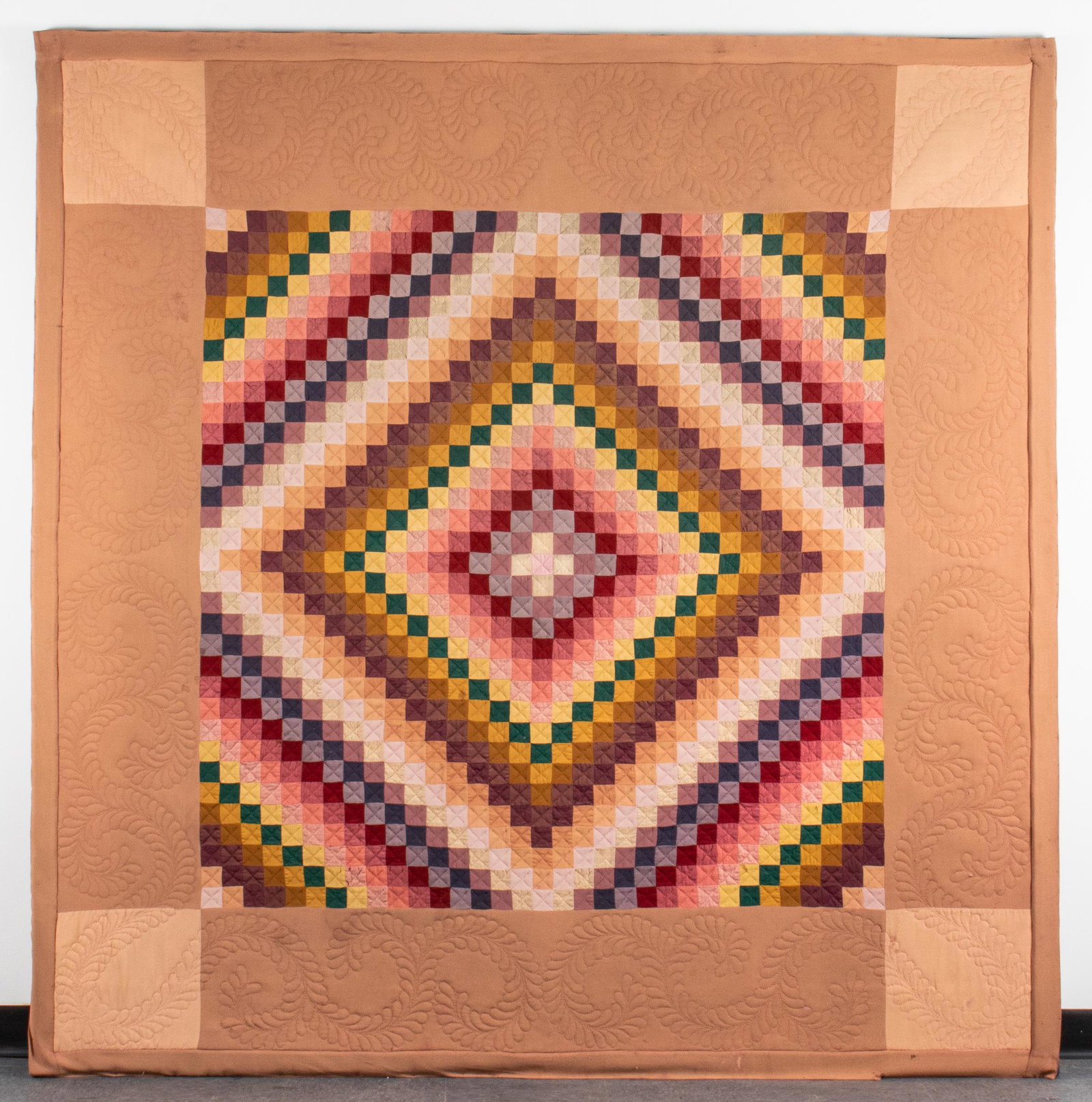 Amish Quilt, "Trip Around the World" Pattern: Amish pieced and quilted coverlet in "Trip Around the World" or "Sunshine and Shadow" pattern, the multicolored patchwork center with beige and sand border, quilted with scrolled foliate stitching, se
