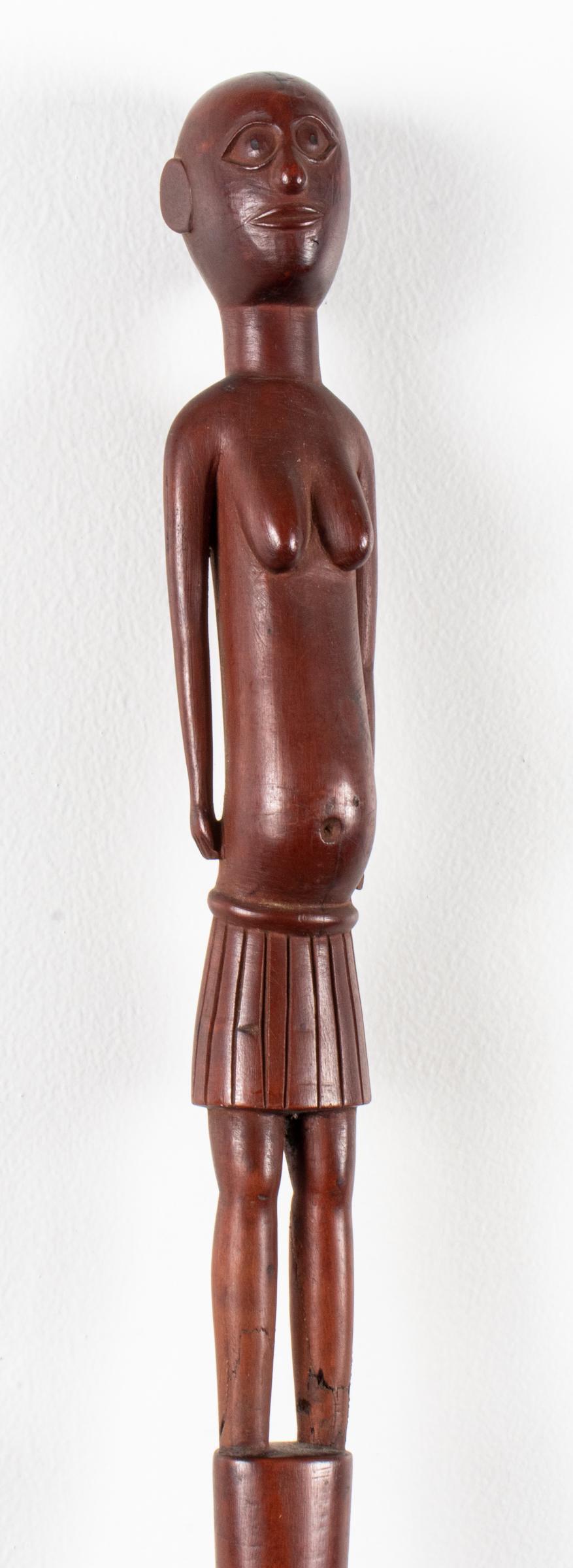 Folk Art Carved Wood Figural Effigy Cane: Folk Art carved wood effigy walking stick / cane, the handle in the form of female figure with exposed torso and pleated skirt, the end with metal ferrule. 36.5" L.