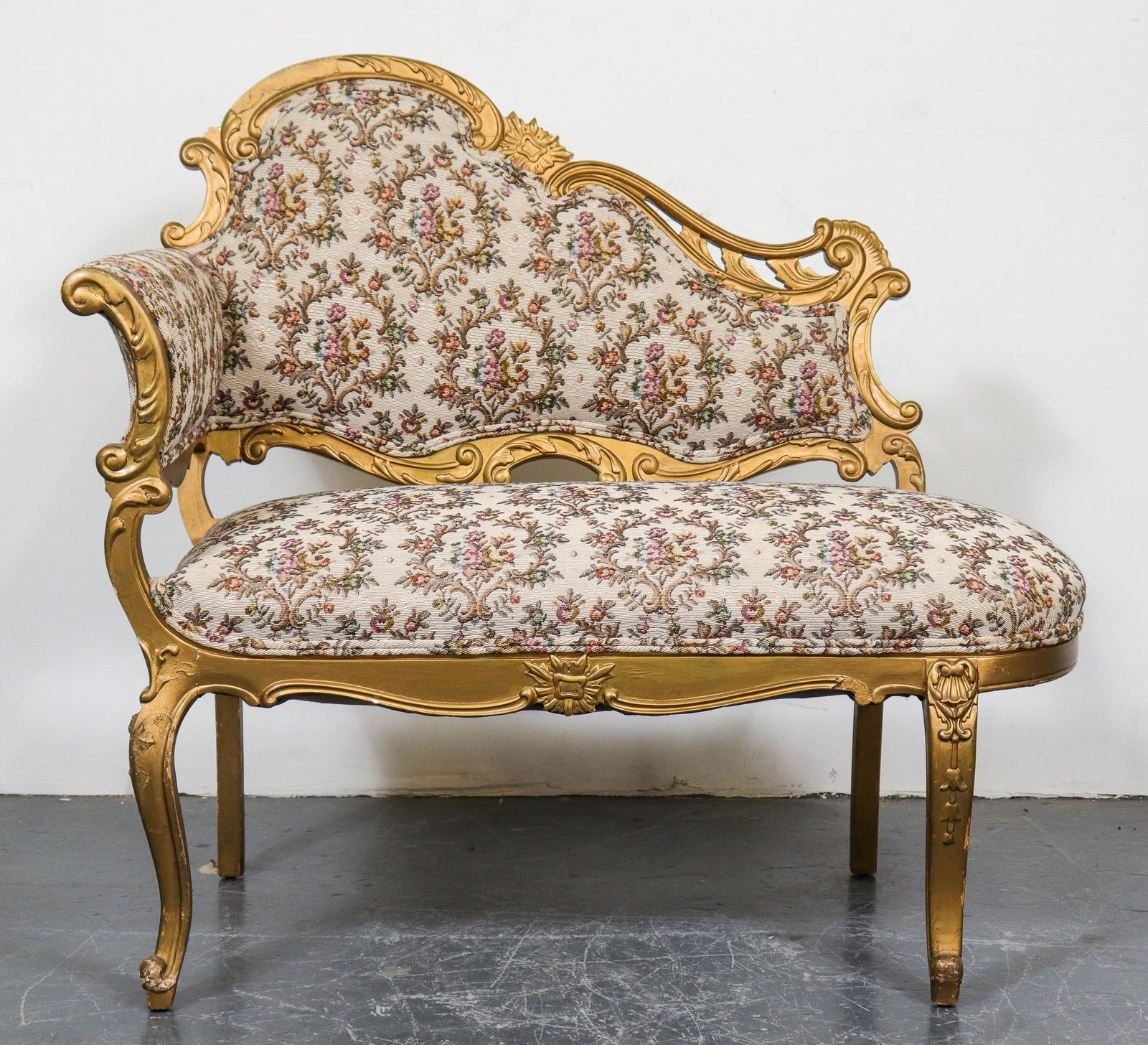 Victorian Floral Upholstered One Arm Settee: Victorian one arm / open settee, with carved giltwood frame and floral upholstery. 36" H x 40" W x 19" D. Minor losses to gilt.
