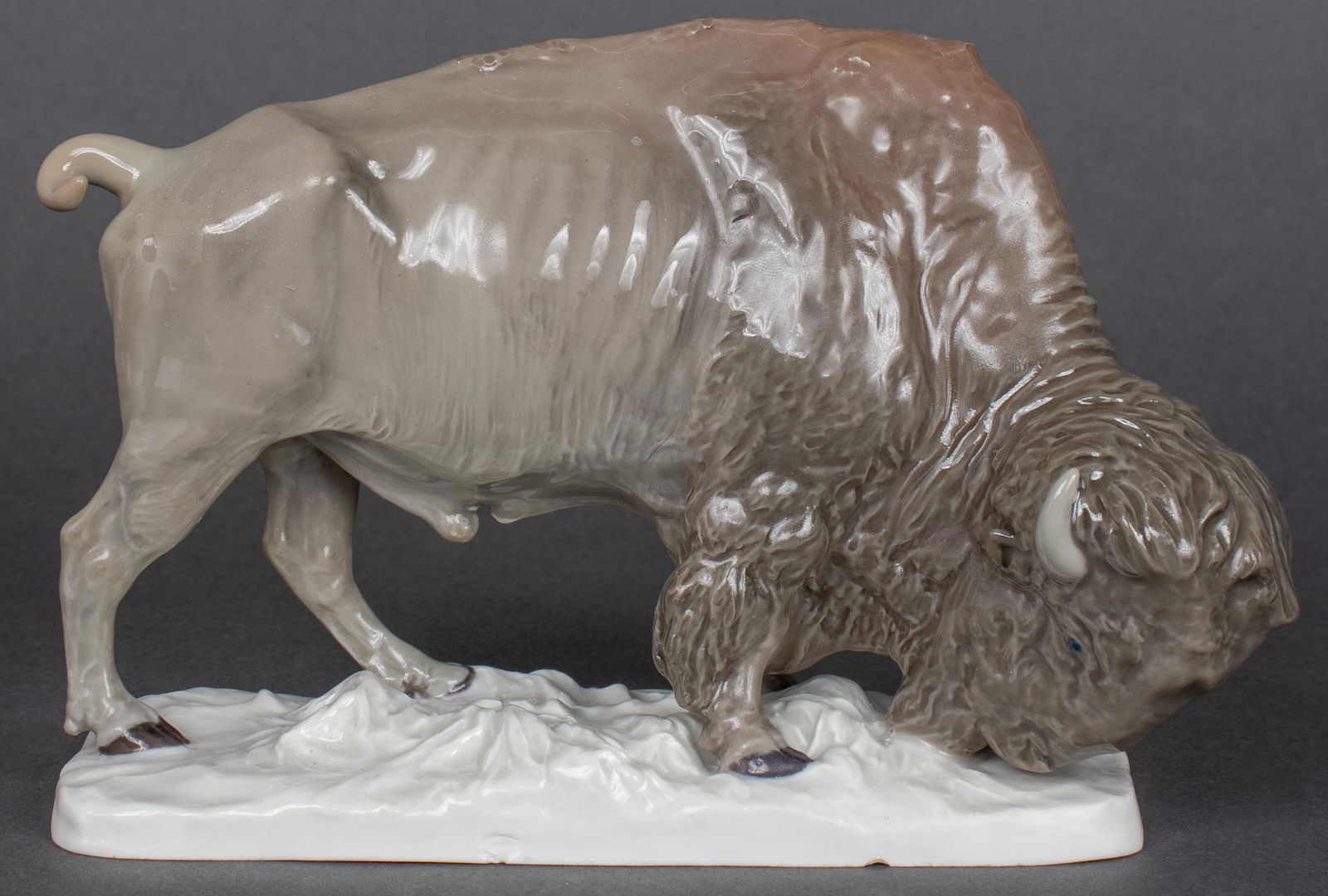 Meissen "Bison" Porcelain Figurine: Meissen porcelain figurine of a bison, early 20th century, naturalistically painted in underglaze colors, bears Meissen blue crossed swords mark on underside and impressed "39" and other markings. 4.5