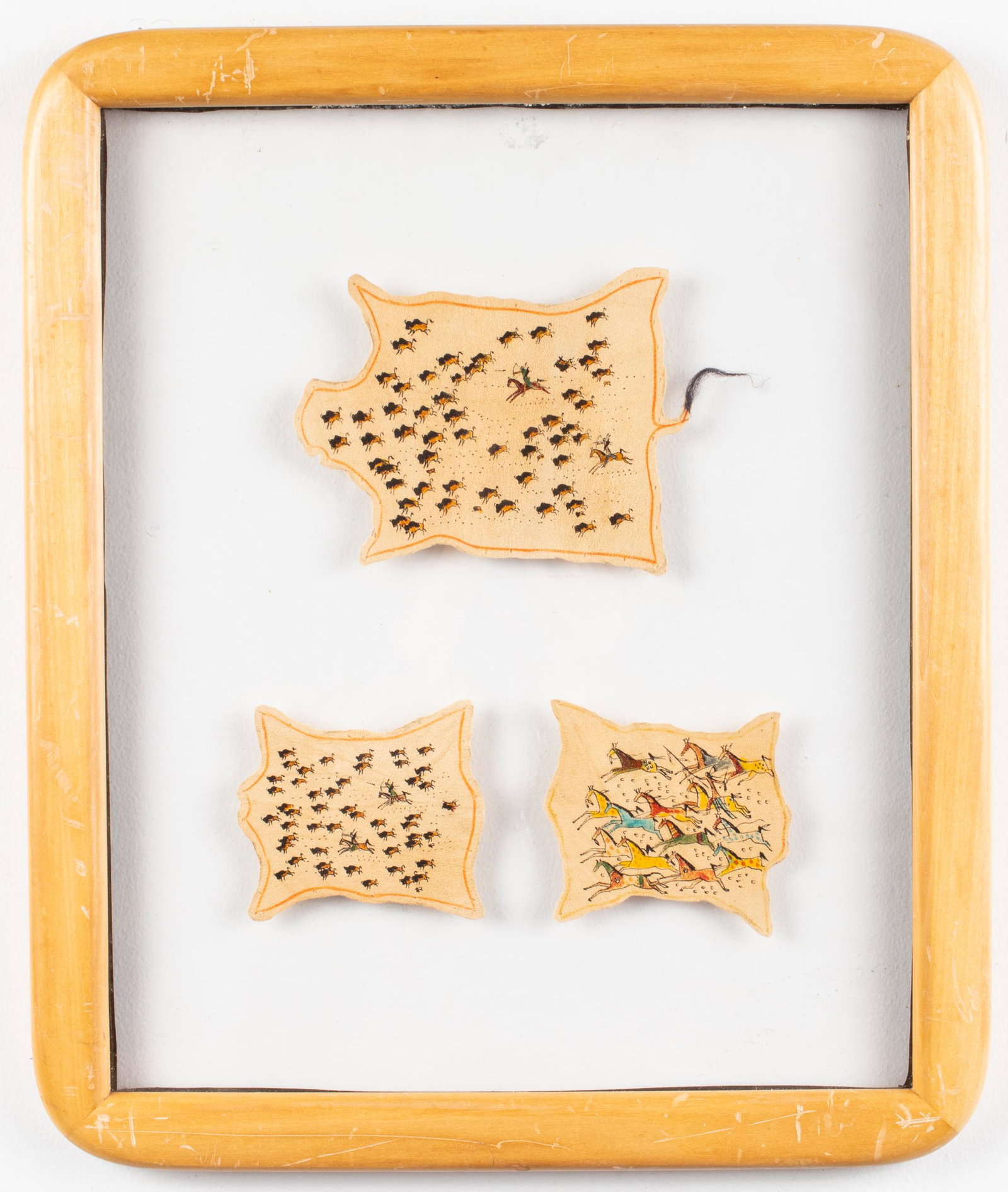 Rainbow Hand "Sioux Hunt" Pictograms on Hide: Rainbow Hand set of three pictograms on hide, each labeled with titles and artist's name in handwriting to reverse, set in single frame. 14" H x 11.5" W; frame: 16.5" H x 14" W x 1" D.