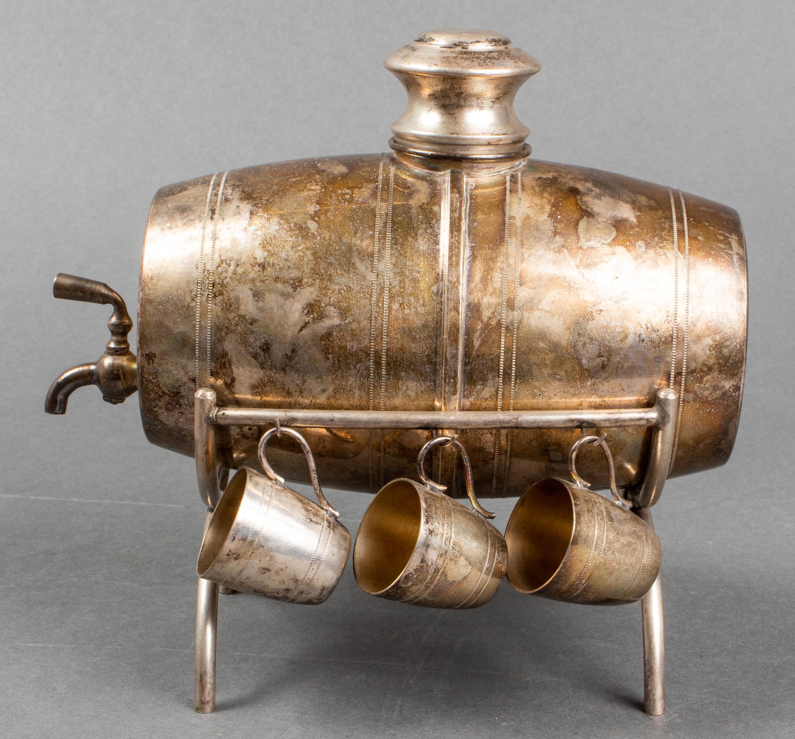 Judaica Barrel Form Wine Dispenser & Cups: Judaica silver-plate barrel-form wine dispenser with six cups. 7.5" H x 8" L x 5" W.