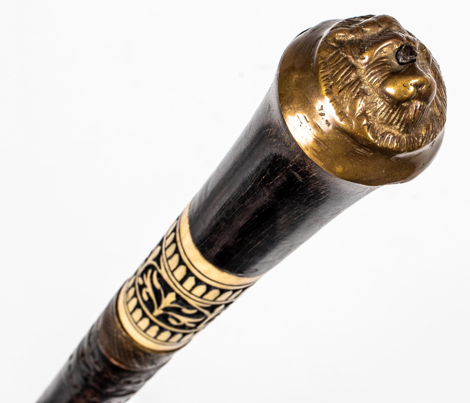 Carved Wood & Bone Inlaid Walking Stick: Carved wood walking stick with bone inlay and brass mounts including ferrule and lion motif knob. 36.75" L. Provenance: From the estate of American film producer Martin Bregman (Scarface, Serpico, Dog
